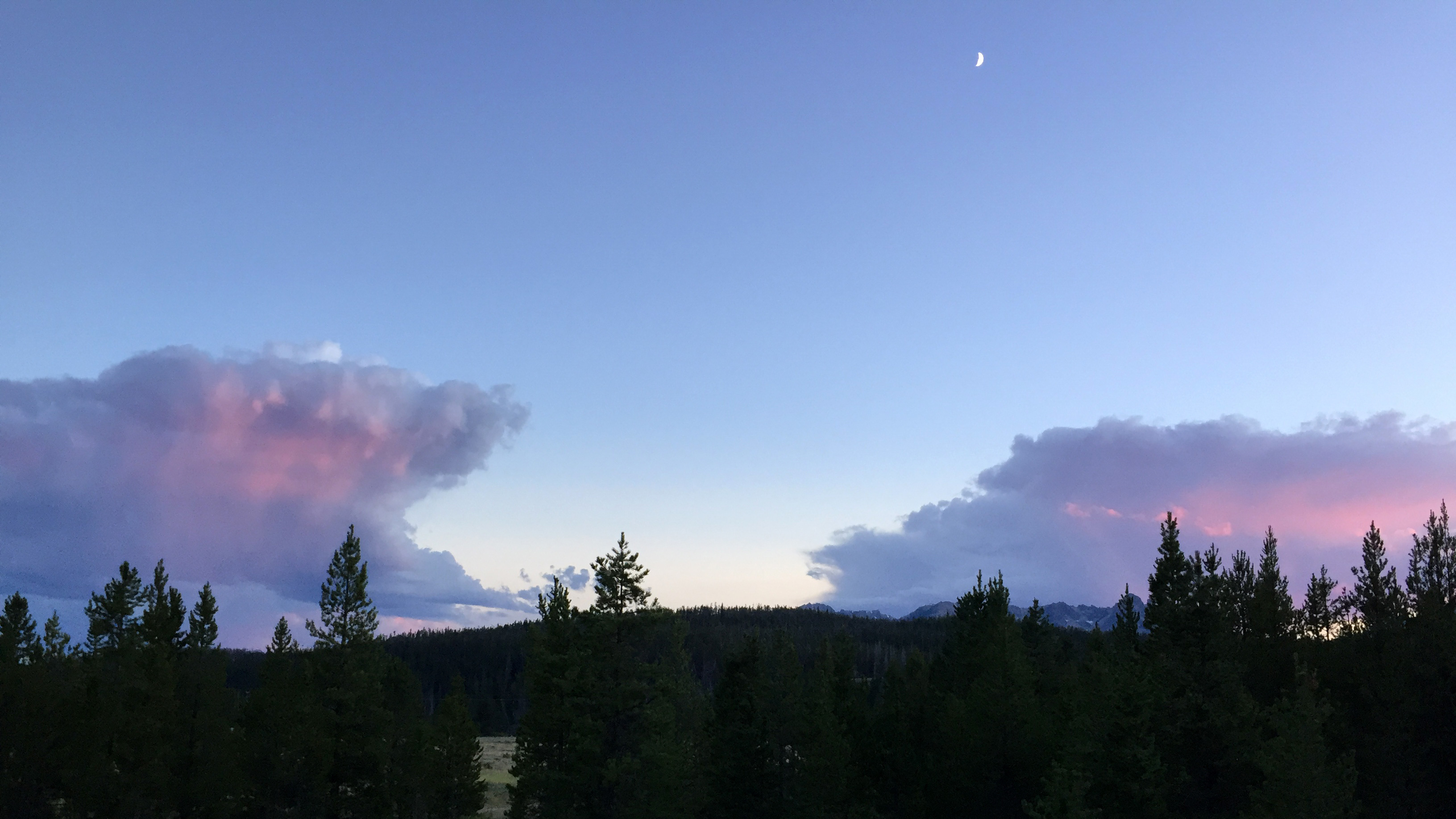 The moon is high as twilight descends on the hills and woods on the outskirts of the small Idaho mountain town of Stanley. On a clear night, the galactic dust of the Milky Way is visible overhead.