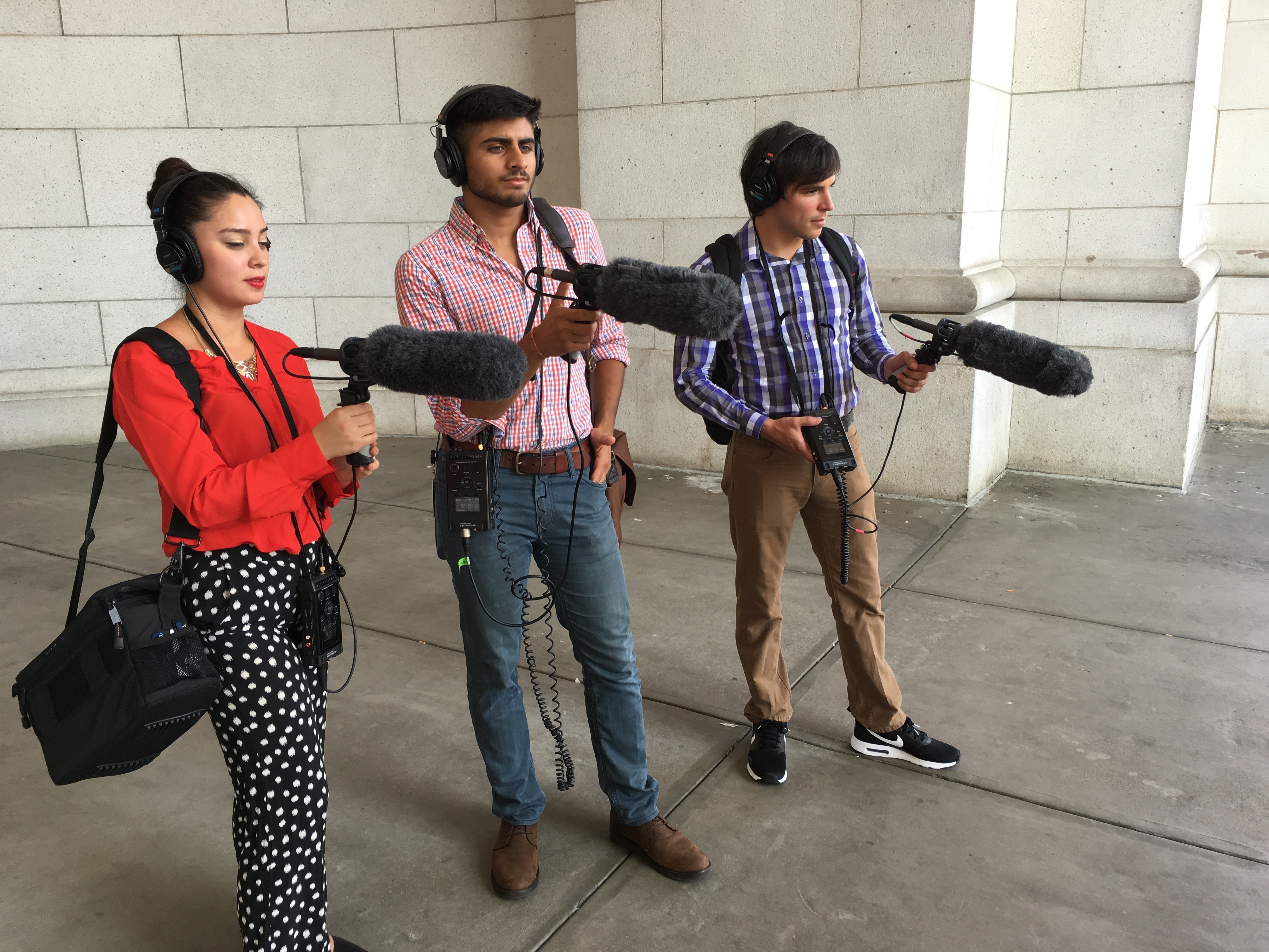 2016-2017 Kroc Fellows Jessica Diaz-Hurtado (left), Parth Shah and Stephan Bisaha practice their recording technique at Union Station in Washington, D.C. Fellows receive hands-on training in audio and digital storytelling. (NPR)