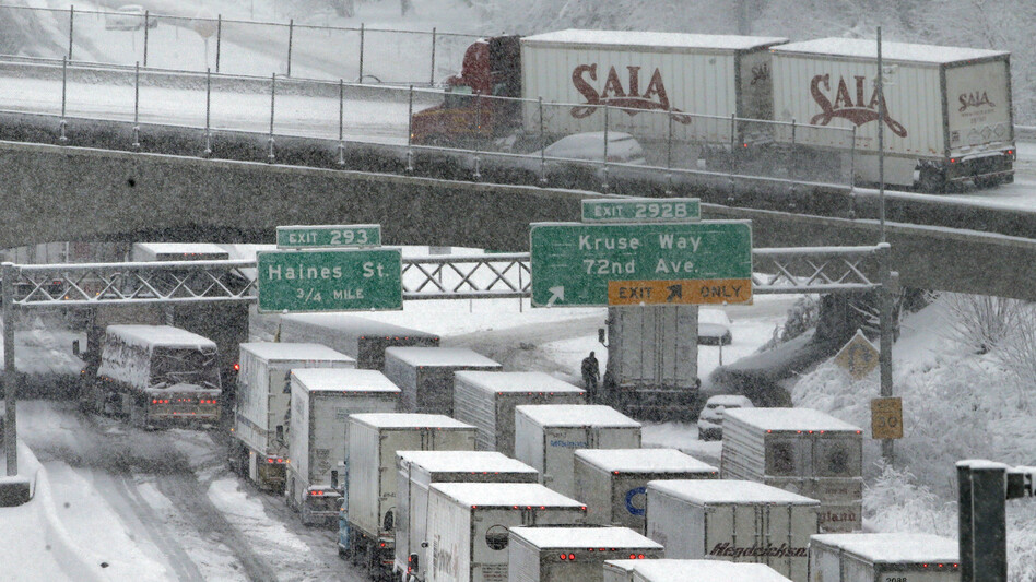 Early-morning traffic backs up on Interstate 5 during a Jan. 11 snowstorm in Portland, Ore. Truck drivers say such conditions, combined with limitations on their working hours, cost them a lot of money because of their mileage-based pay. (Don Ryan/AP)