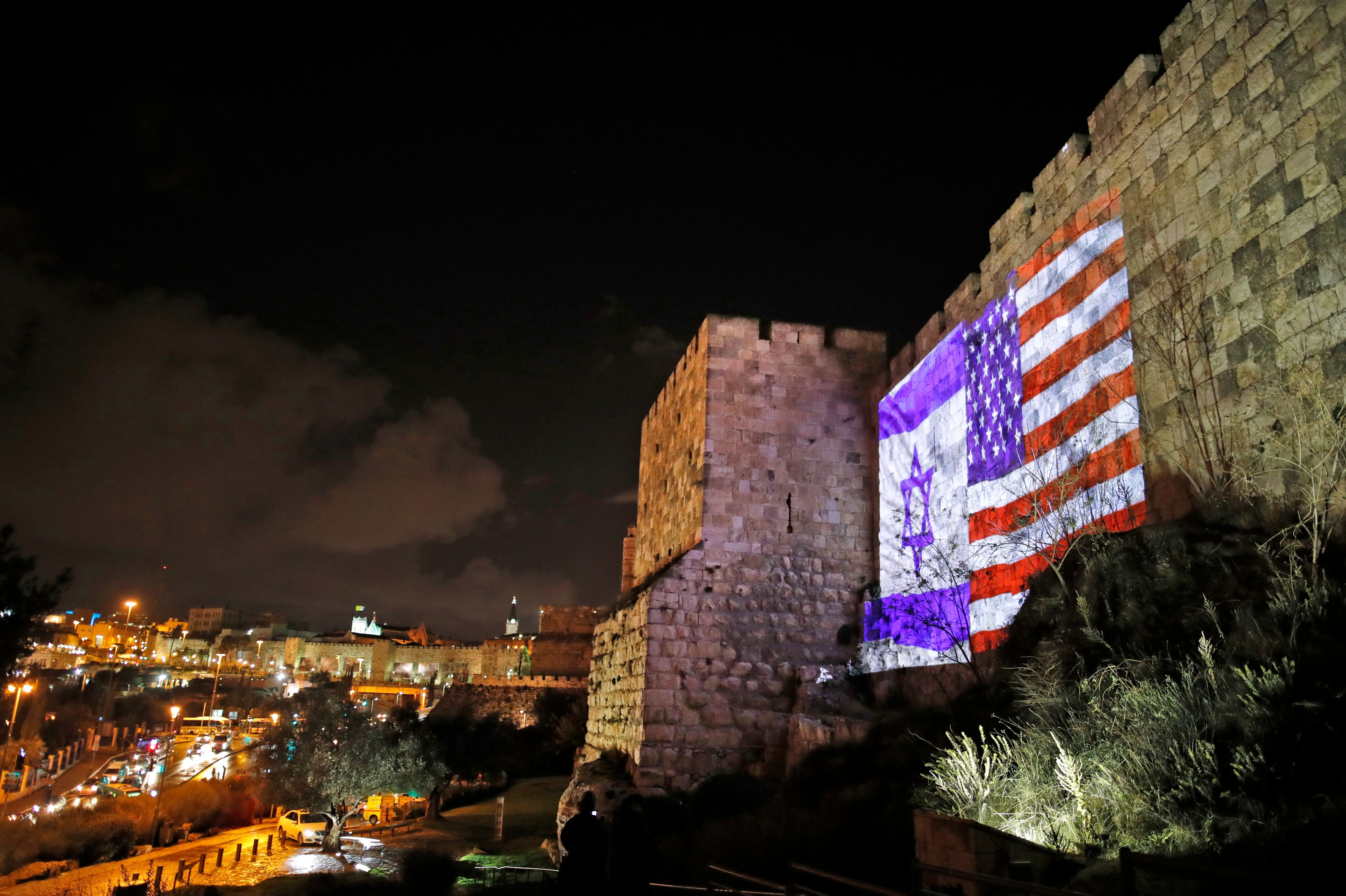 The American and Israeli flags are on display Wednesday on the walls of the Old City of Jerusalem. President Trump announced that the U.S. will view Jerusalem as the capital of Israel, and he ordered the State Department to &quot;begin preparation to move the American Embassy from Tel Aviv.&quot; The controversial move threatens to unsettle the region's volatile politics. (AFP/Getty Images)