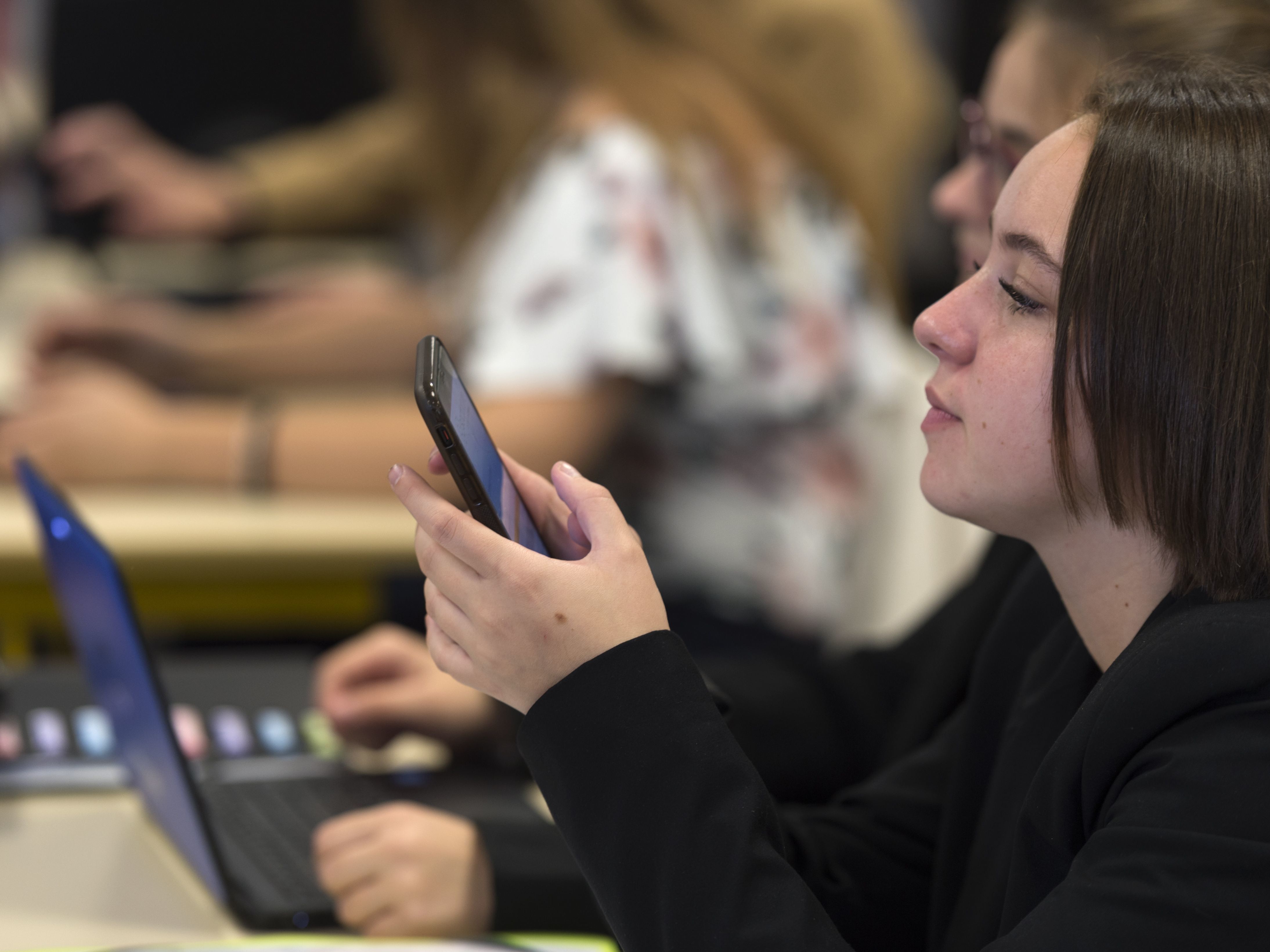 High school students use smartphones and laptops at a vocational school in Bischwiller, France, in September. The country's education minister said he will tighten the ban on phones for elementary and secondary school students, except for educational purposes and emergencies. (AFP/Getty Images)