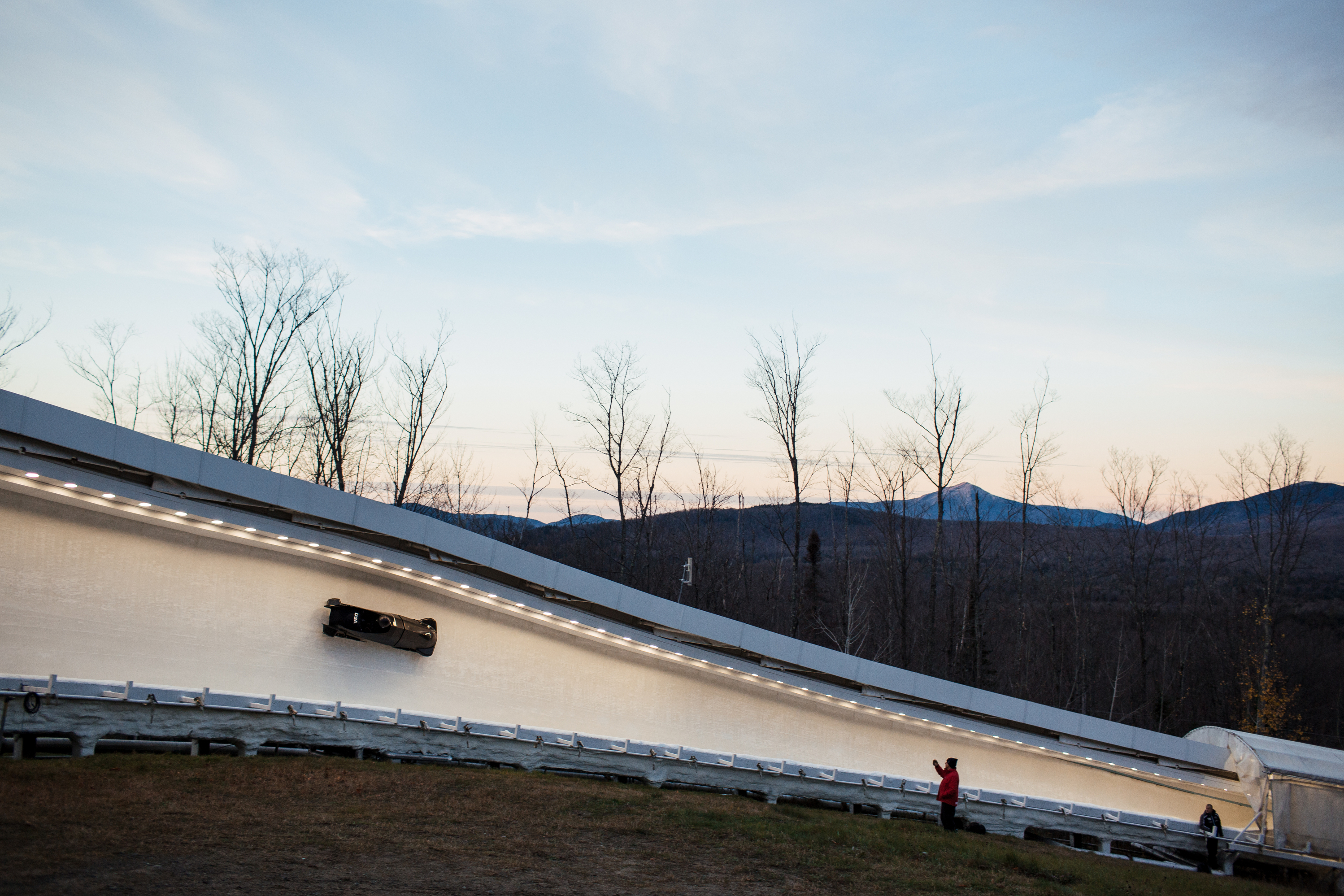 A U.S. sled makes its way through curve 10 on the Lake Placid, N.Y. track during training runs. (John Tully for NPR)