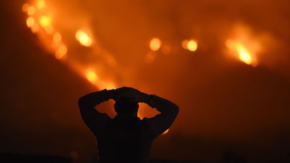 A man watches the Thomas Fire in the hills above Carpinteria, California. (Robyn Beck/AFP/Getty Images)