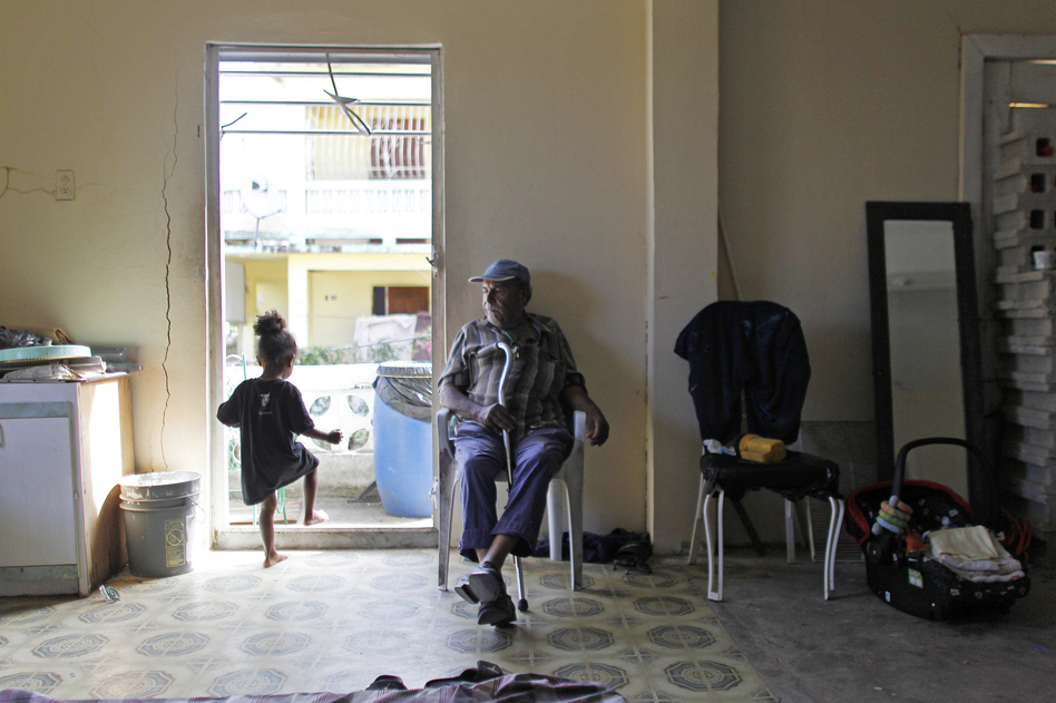 Gregorio Velazquez Rivera, 81, sits inside an abandoned house he now occupies with his relatives after they lost their home to Hurricane Maria in Vieques, Puerto Rico. (Ricardo Arduengo for NPR)