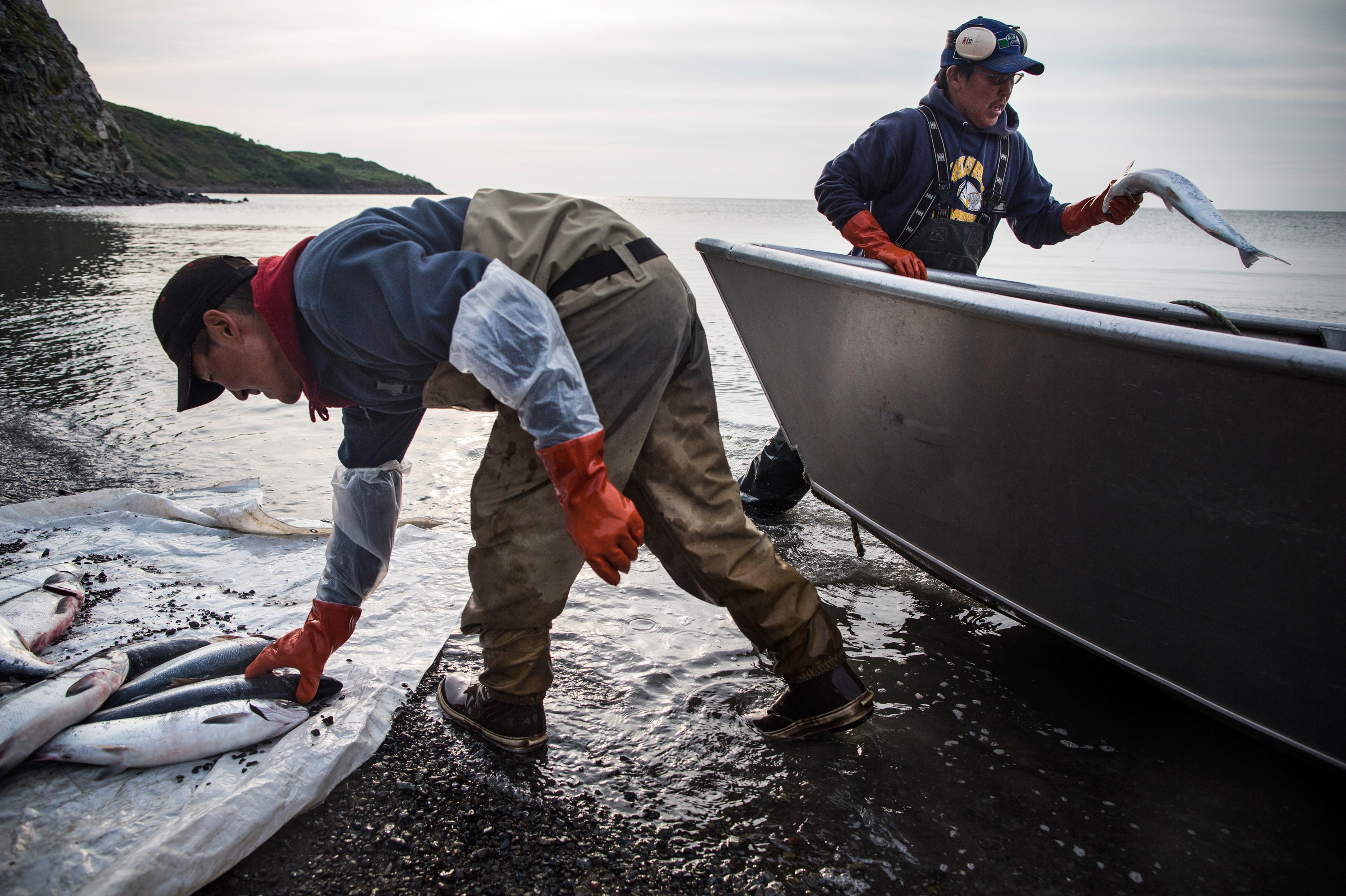For Alaskan Coastal Village, Erosion Hits Home 4 Joseph John Jr. washes freshly caught salmon with his son, Jeremiah John, while waiting for the tide to come in on July 1, 2015 in Newtok, Alaska. Families in the village of roughly 400 people depend on hunting and fishing.