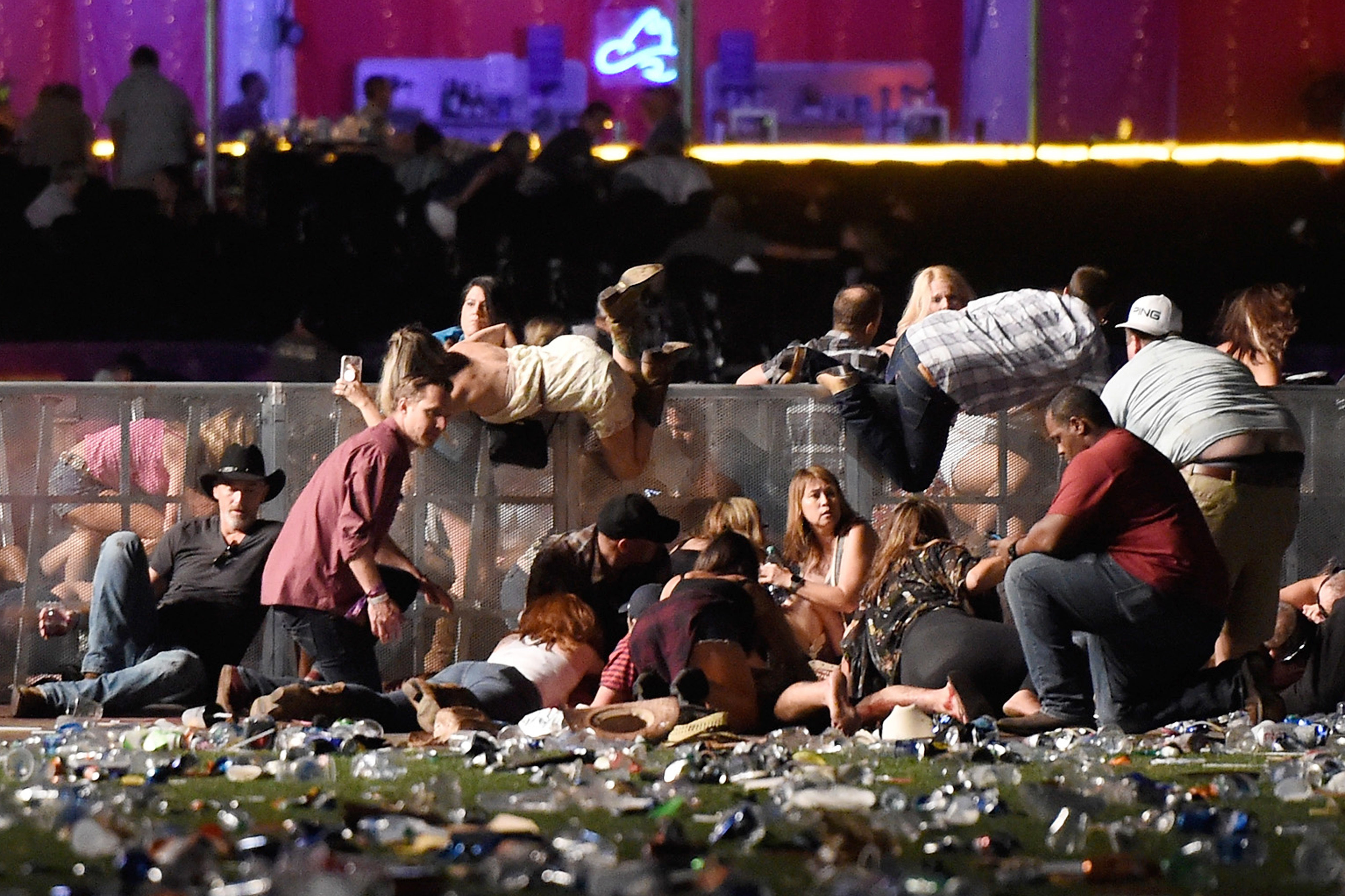 People scramble for shelter at the Route 91 Harvest country music festival in Las Vegas after gunfire was heard.