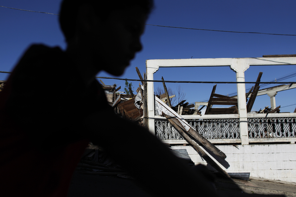 A child rides a bike by a house destroyed by Hurricane Maria in Vieques, Puerto Rico. (Ricardo Arduengo for NPR)