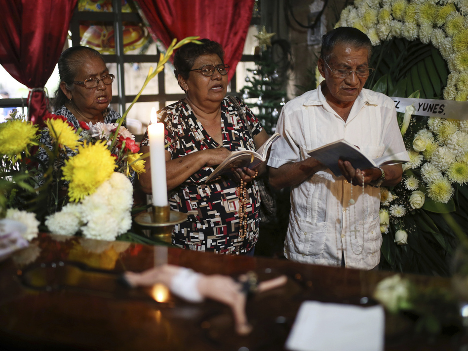 People pray next to the coffin of slain journalist Gumaro Pérez Aguilando during his wake at his mother's home in Acayucan, Veracruz state, Mexico, on Wednesday. (Felix Marquez/AP)