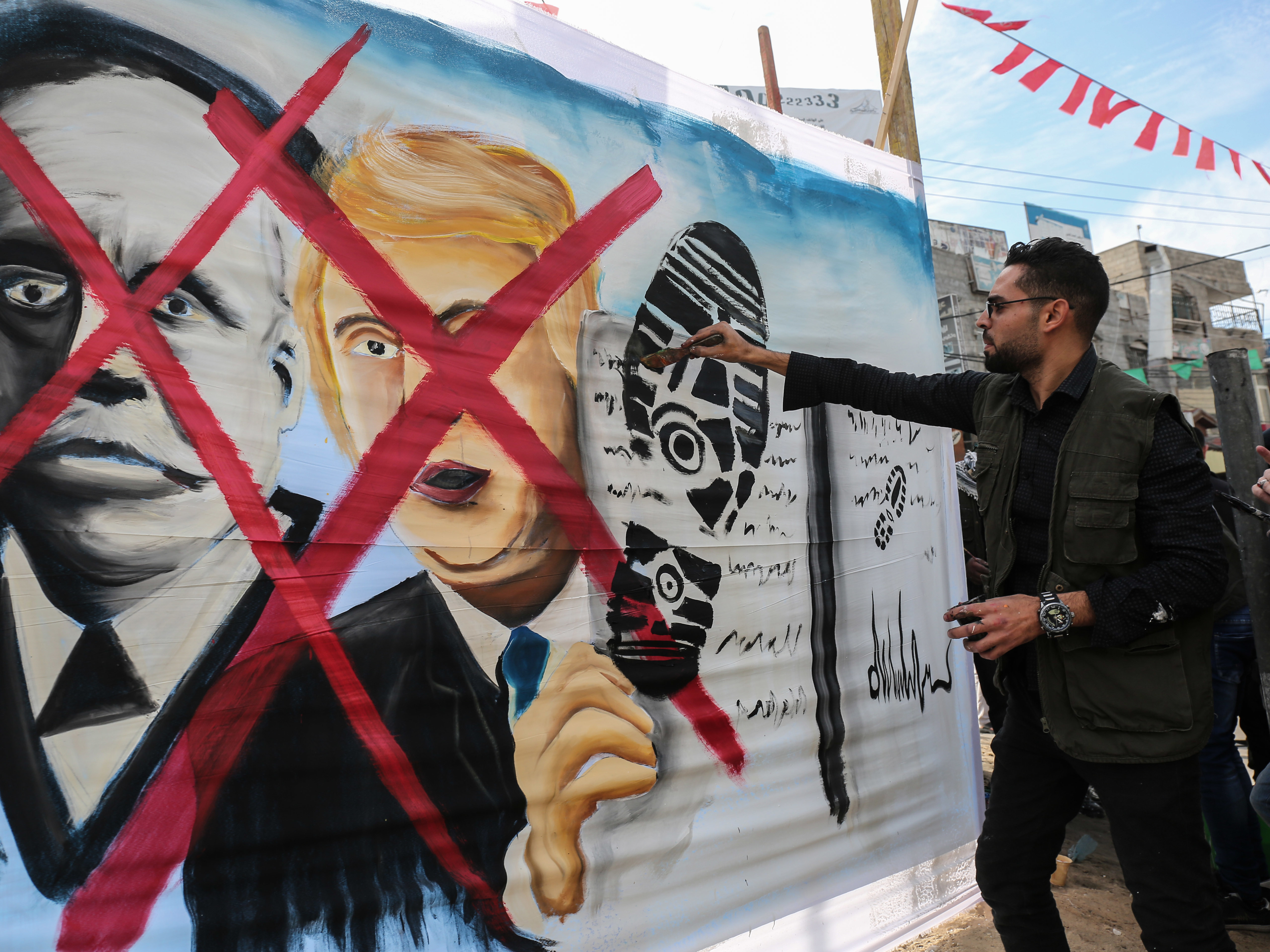 A Palestinian paints a picture showing President Trump and the sole of a shoe in the Gaza Strip on Wednesday. (AFP/Getty Images)
