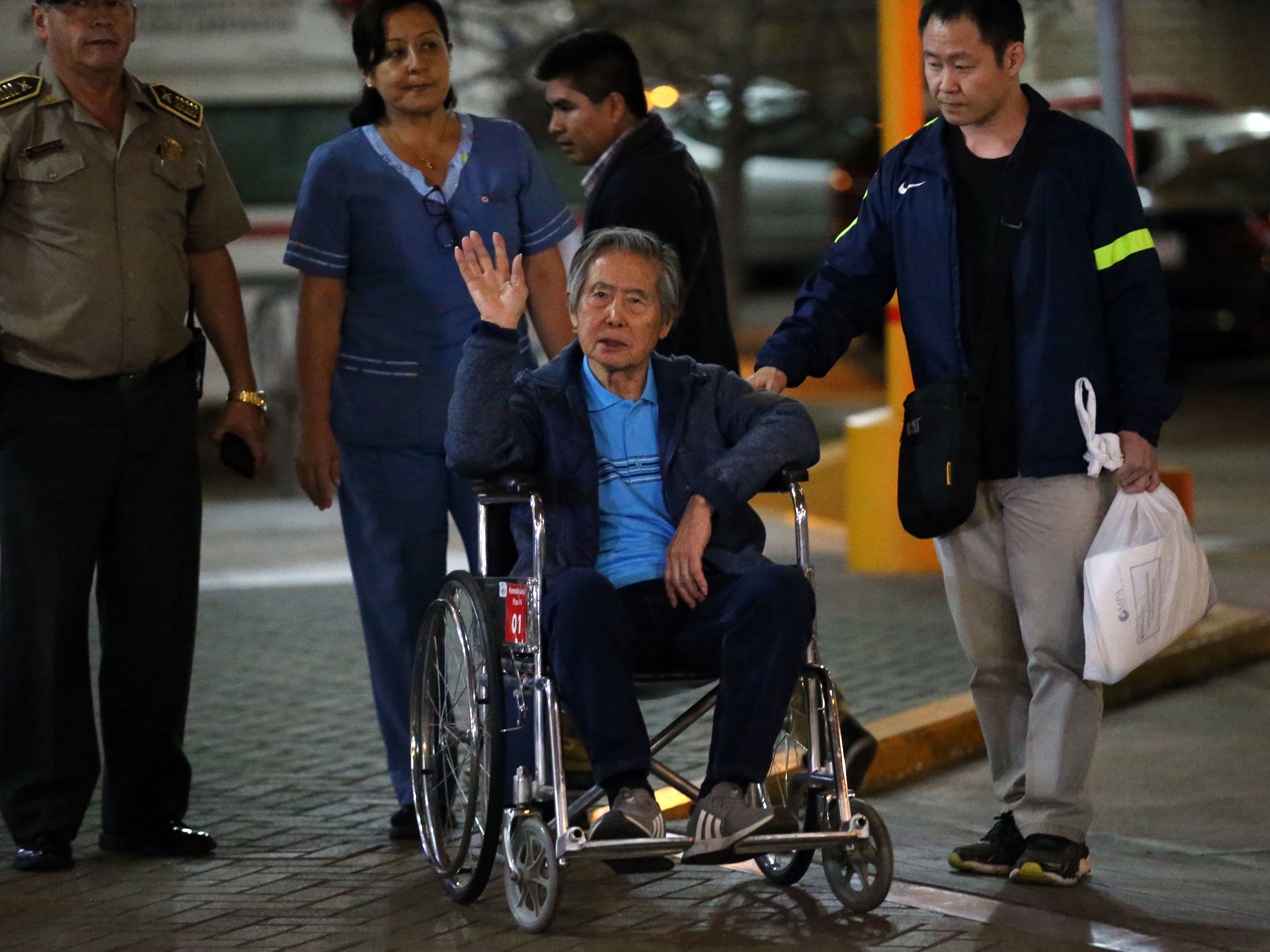Former President Alberto Fujimori waves to supporters Thursday as he is wheeled out of a hospital, where he received his Christmas Eve pardon from President Pedro Pablo Kuczynski. (AFP/Getty Images)