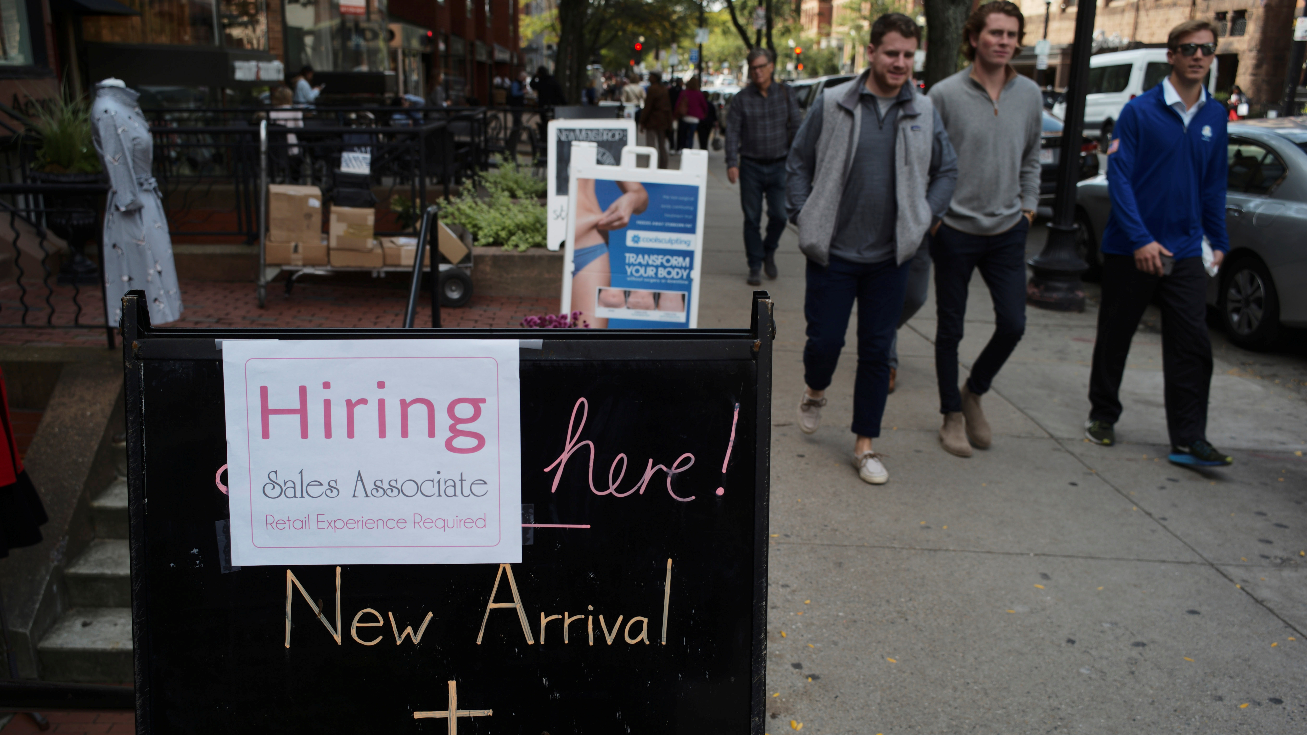 Retail jobs have taken a hit, losing 67,000 jobs in 2017 after seeing a large gain the year before. In this photo from October, people pass a sign advertising a sale and a job at a shop in Boston last fall. (Reuters)