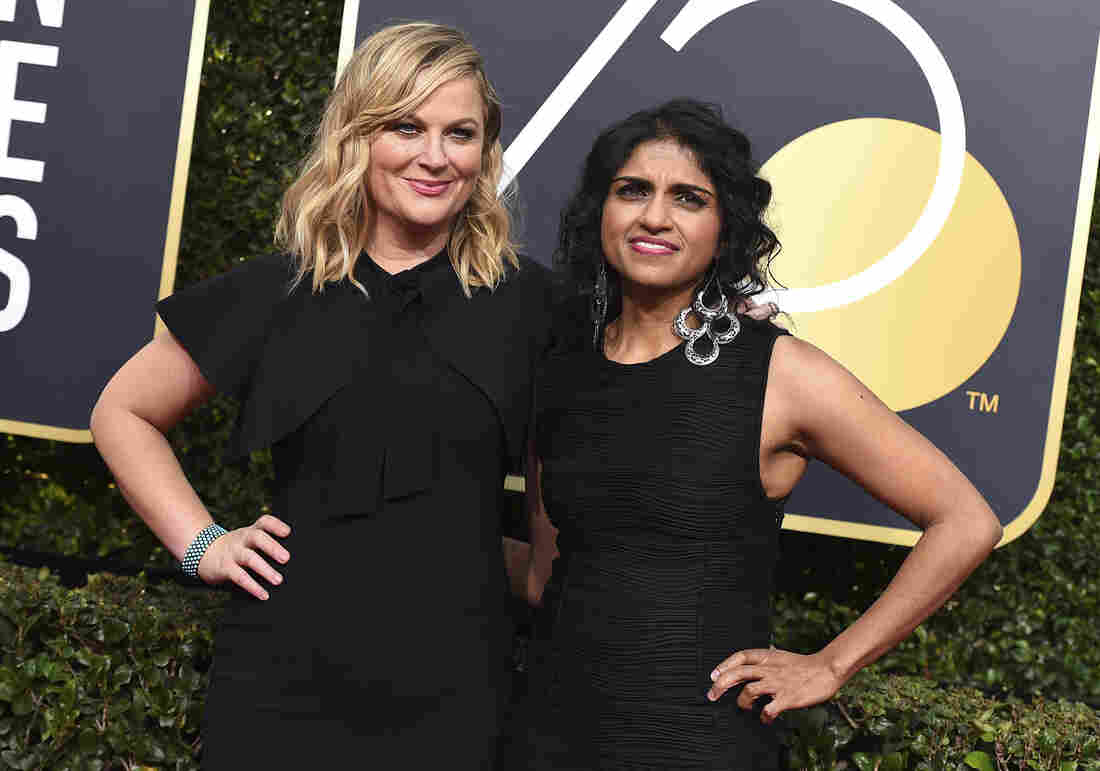 Amy Poehler, left, and Saru Jayaraman arrive at the 75th annual Golden Globe Awards.
