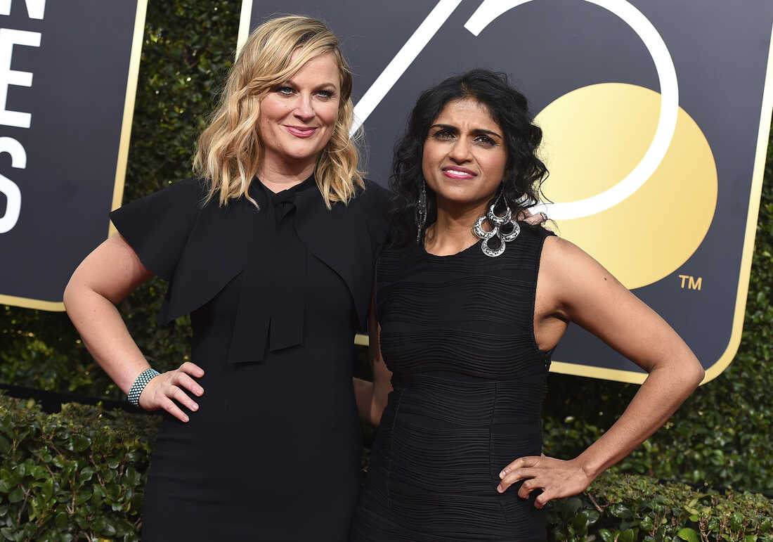 Amy Poehler, left, and Saru Jayaraman arrive at the 75th annual Golden Globe Awards.
