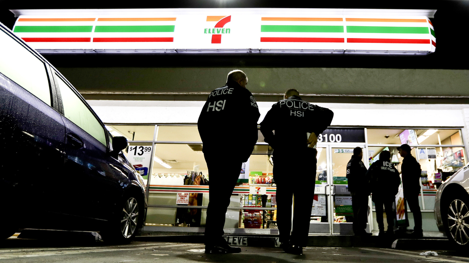 ICE agents serve an employment audit notice at a 7-Eleven in Los Angeles Wednesday. Agents raided 98 stores across the country. (Chris Carlson/AP)