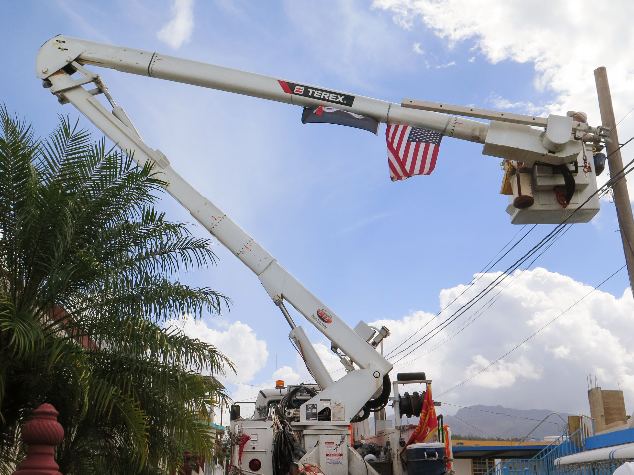 Army reservist Eric Elder, a lineman in civilian life, works with the Corps of Engineers to restore power in the hilly Rio Grande neighborhood east of San Juan. (NPR)