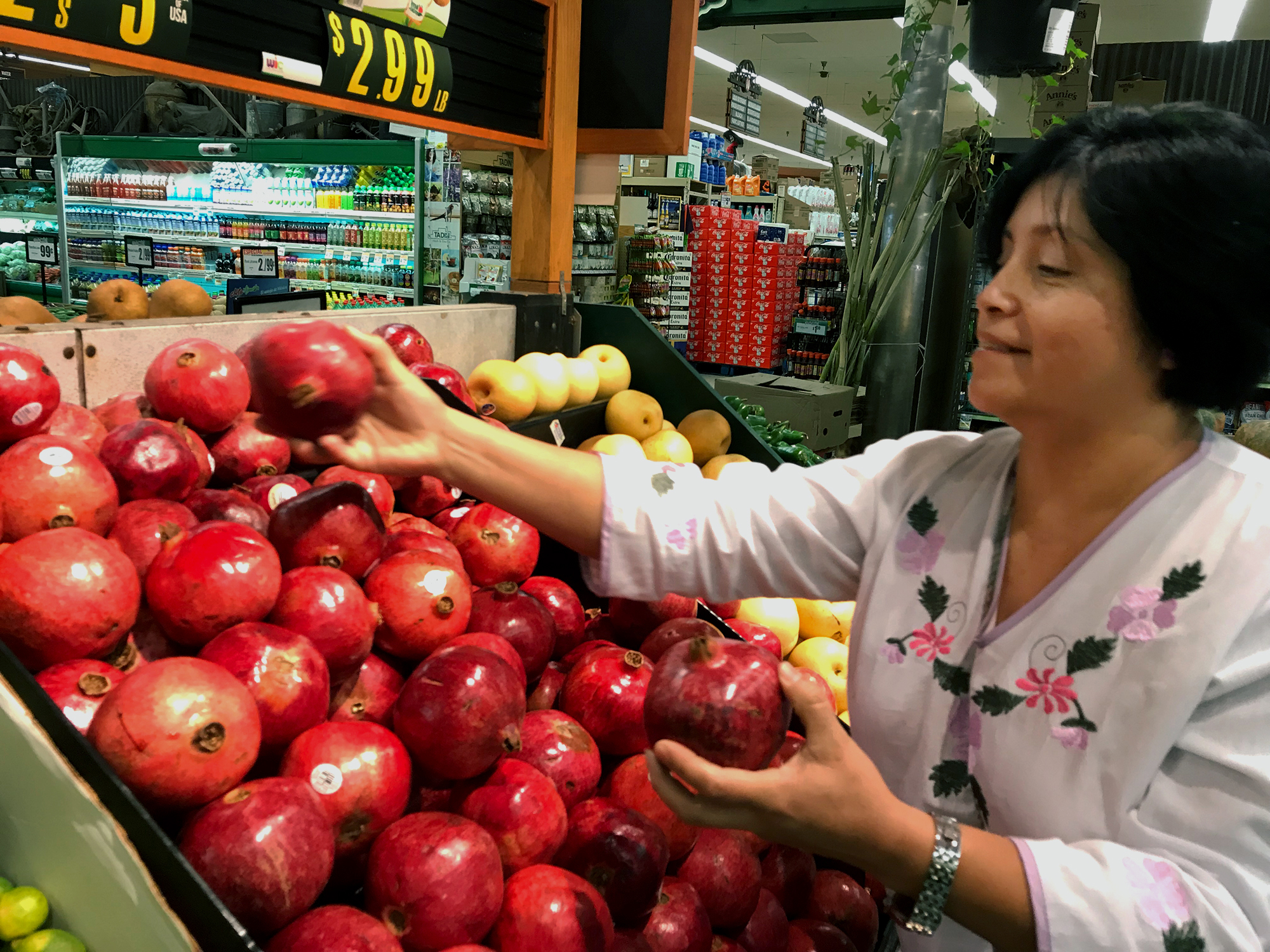 Rebeca Gonzalez says she can now afford to buy pomegranates for her family in Garden Grove, Calif., because of the extra money she receives through Más Fresco, a food stamp incentive program for purchasing produce. (Courtney Perkes/Kaiser Health News)