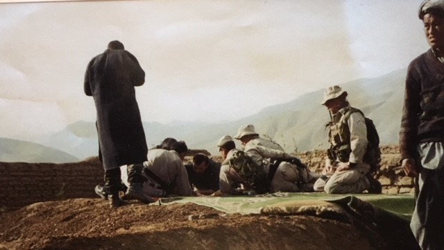 U.S. troops, in tan uniforms, look over maps with Afghan rebel commander Rashid Dostum (center) in October 2001. A dozen U.S. soldiers teamed up with Dostum
