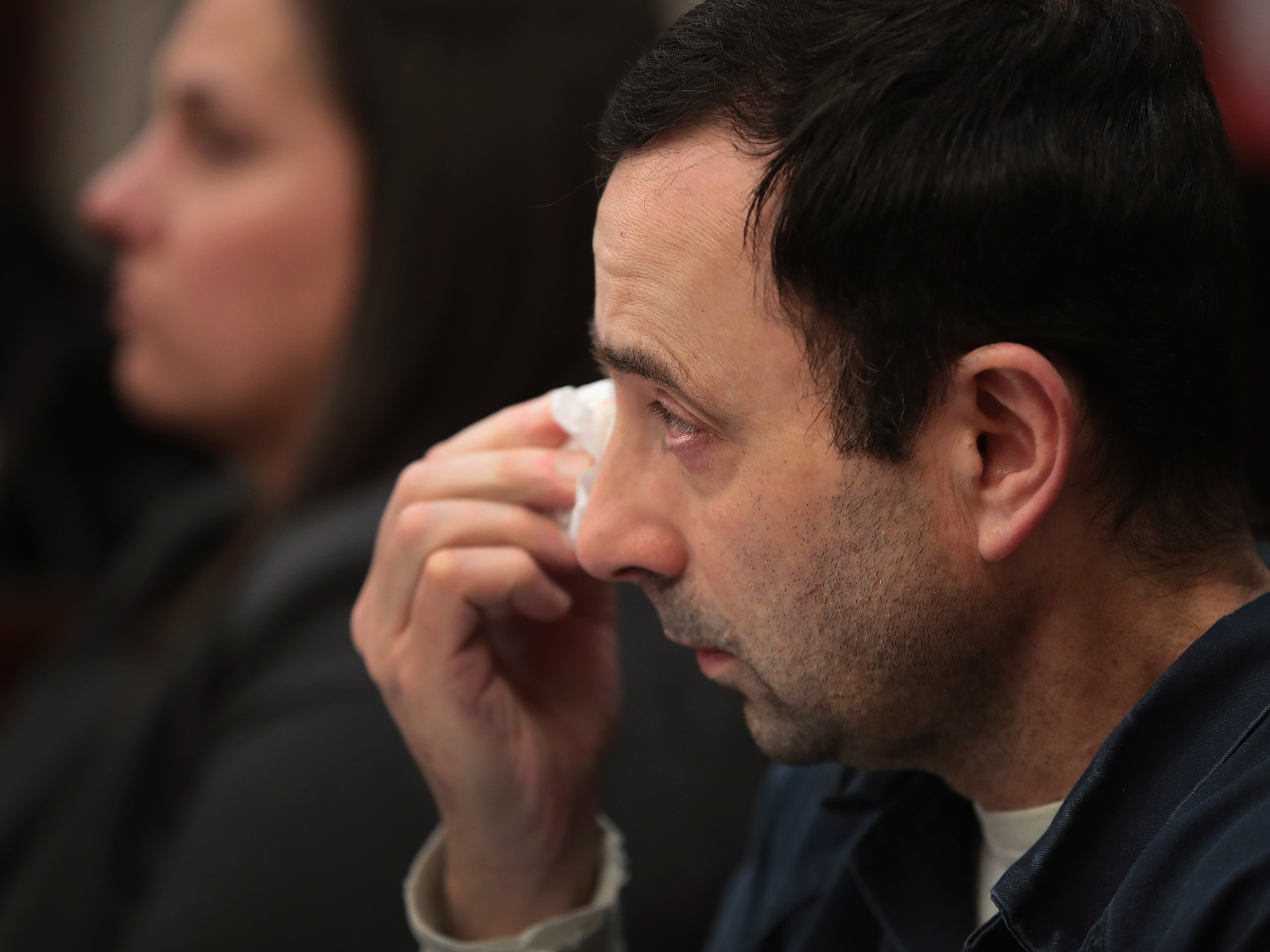 Larry Nassar wipes a tear as he listens to a young woman deliver a victim impact statement at his sentencing hearing on Wednesday. Nassar has pleaded guilty to sexually assaulting seven girls but the judge is allowing more than 100 of his accusers to speak. (Getty Images)