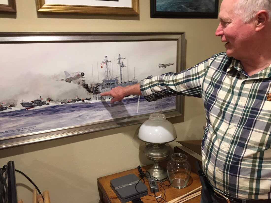 Bob Chicca points to the spot on the deck of the USS Pueblo where a 57 mm shell wounded him during the attack on the ship by North Korea. (NPR)