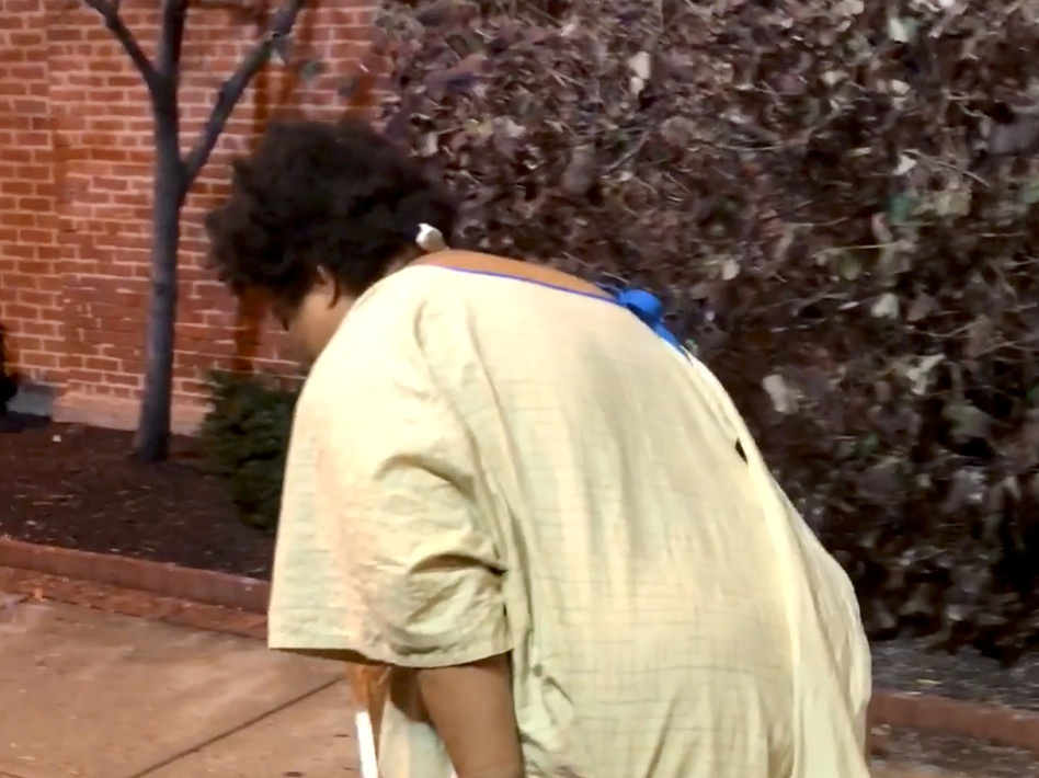 A woman discharged from a Baltimore hospital, later identified as Rebecca, was captured on video by passerby Imamu Baraka. (Imamu Baraka/Reuters)