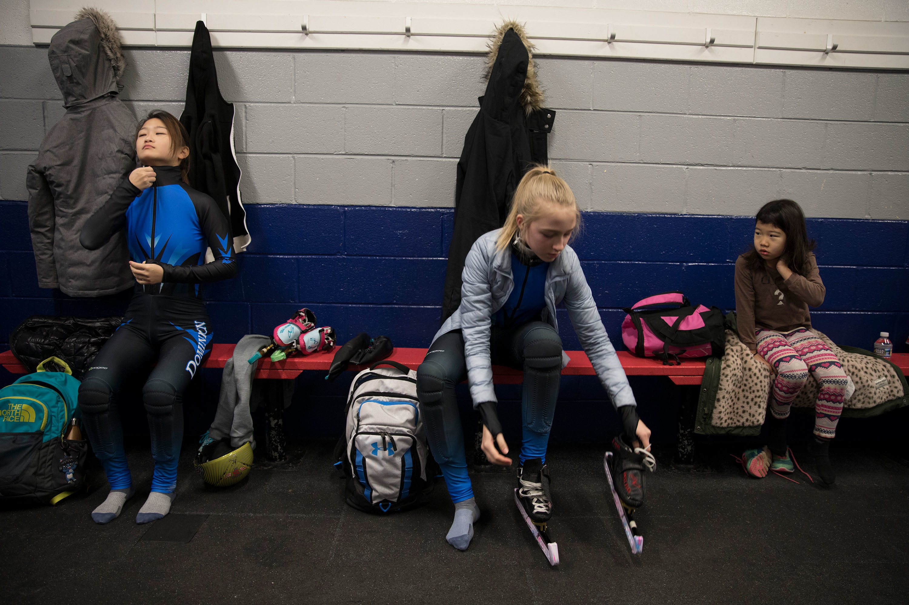 Kyubin Oh, 14, (left) Kamryn Lute, 13, and Ariel Chun, 7, get dressed for their 4:30 a.m. practice in Reston, Va., outside Washington, D.C. (WAMU)