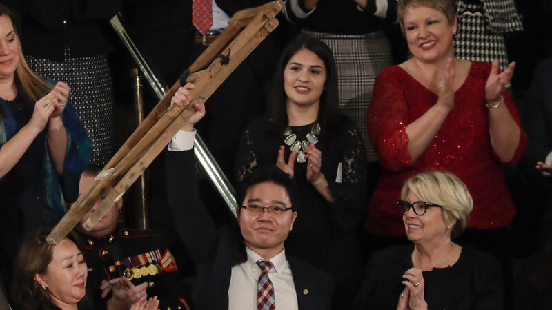 Ji Seong-ho holds up his crutches after his introduction by President Trump during the State of the Union address on Tuesday. (J. Scott Applewhite/AP)