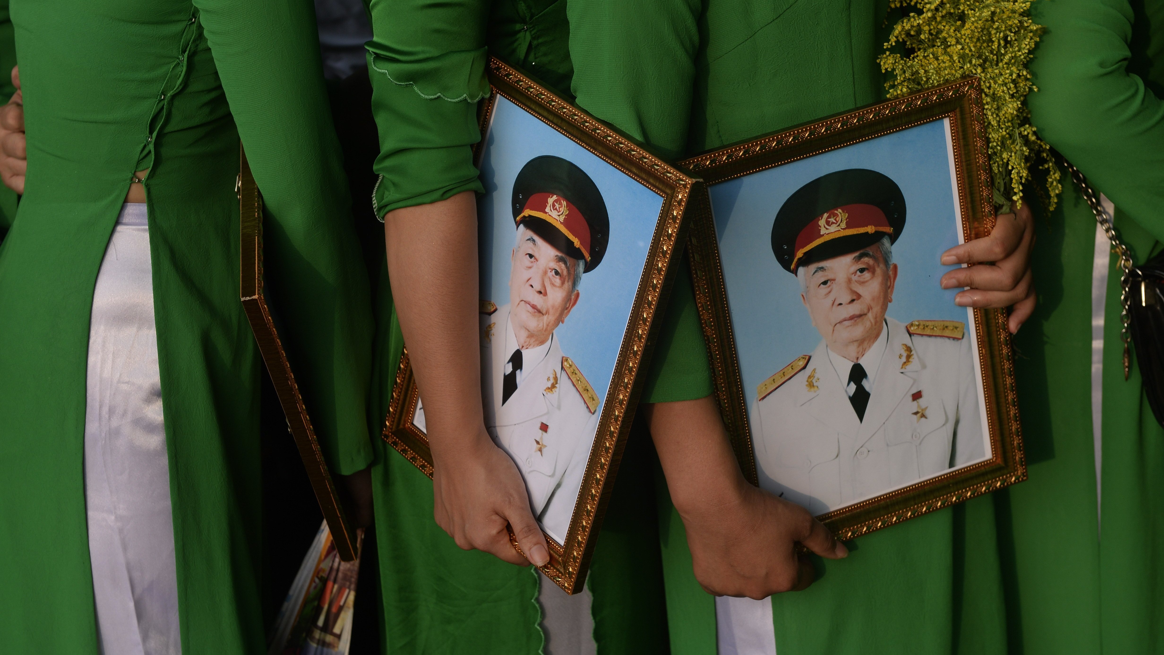 A photo taken in 2013 shows women in traditional dress holding framed portraits of the late Gen. Vo Nguyen Giap as they line up to pay final respects to him at his residence in Hanoi.