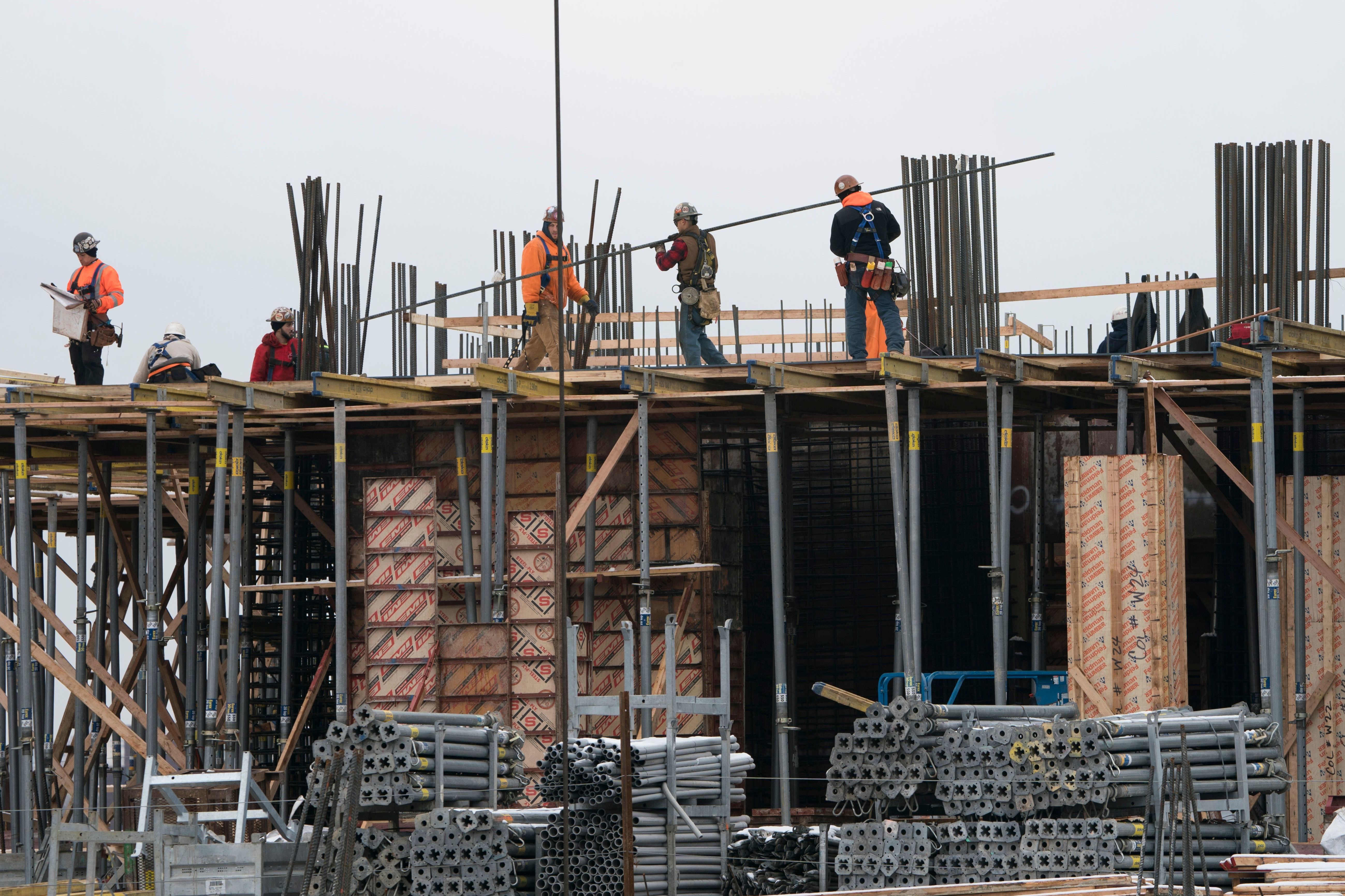 Construction workers work on a building on the west side of Manhattan on Tuesday in New York. The rise in employment was driven by the construction industry, restaurants, health care and manufacturing, all sectors that added jobs last month. (AFP/Getty Images)