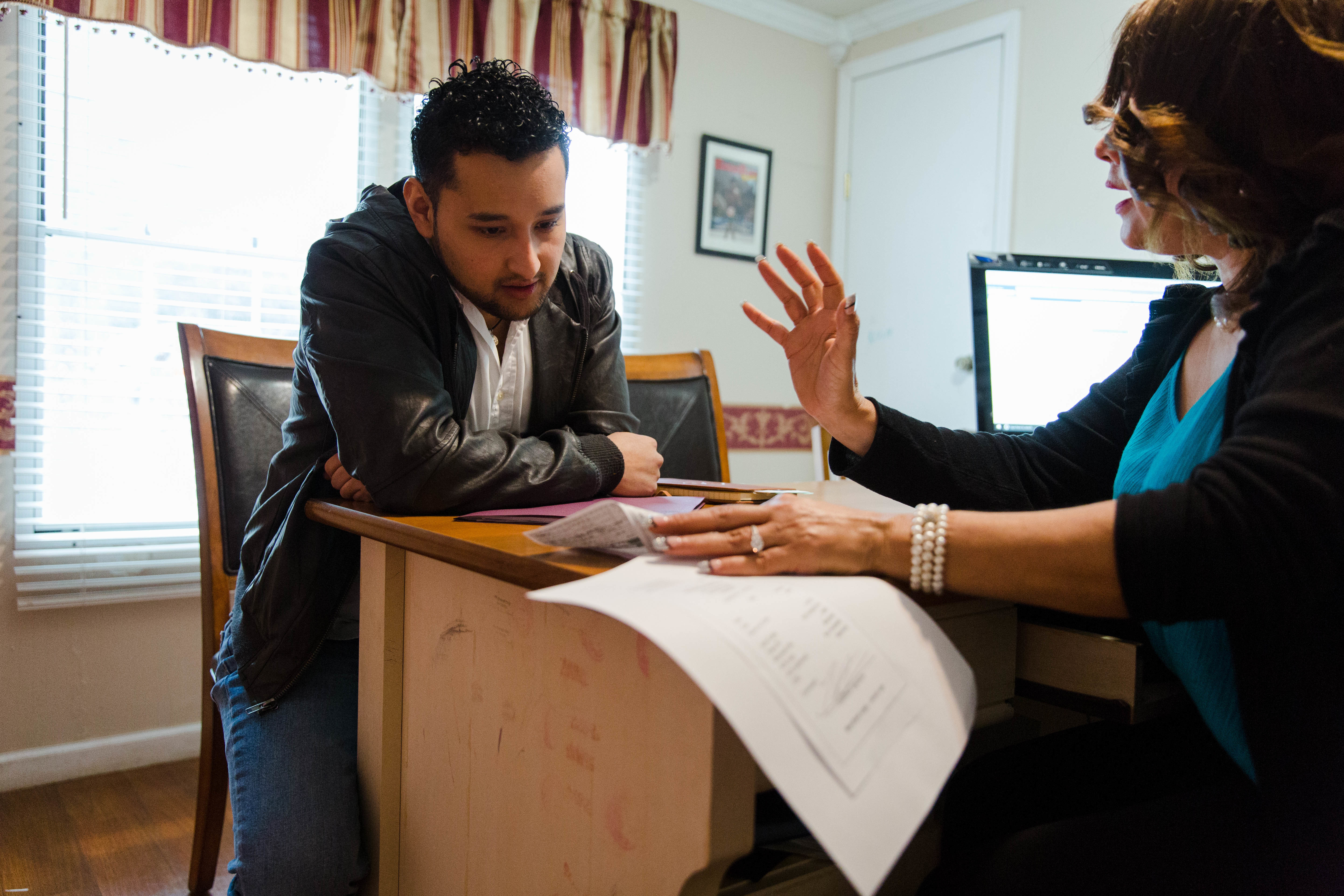 Christian Olvera, a DACA recipient, talks with public notary Enedina Acosta about his taxes. (Kevin D. Liles for NPR)