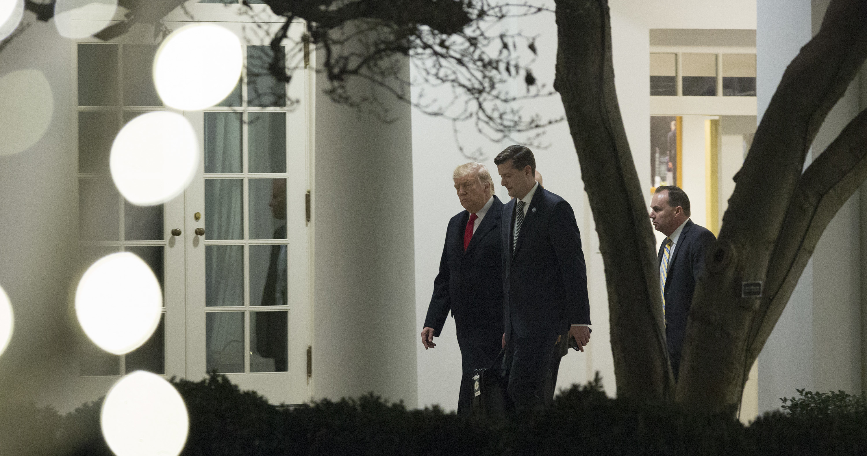 President Trump speaks with White House secretary Rob Porter (center) and Sen. Mike Lee, R-Utah, outside the White House in December. Porter resigned this week amid allegations of domestic violence against his ex-wives. (Getty Images)