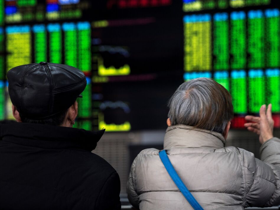 Two investors chat while keeping an eye on stock price movements shown on a screen at a securities company in Shanghai on Friday. (Johannes Eisele/AFP/Getty Images)