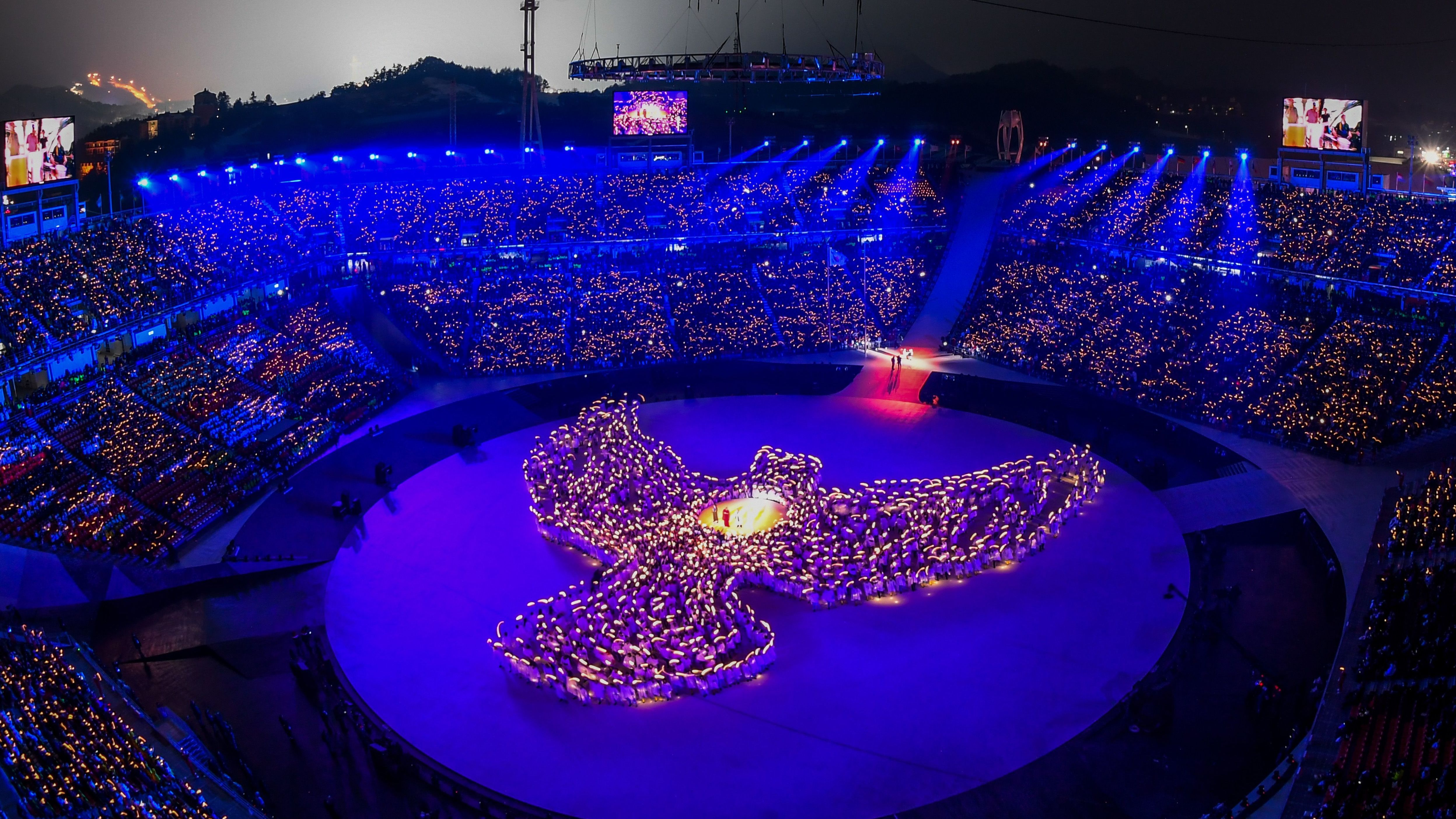 More than 1,200 people, including 1,000 residents of Gangwon Province, form the shape of a dove out of candlelight during the opening ceremony.