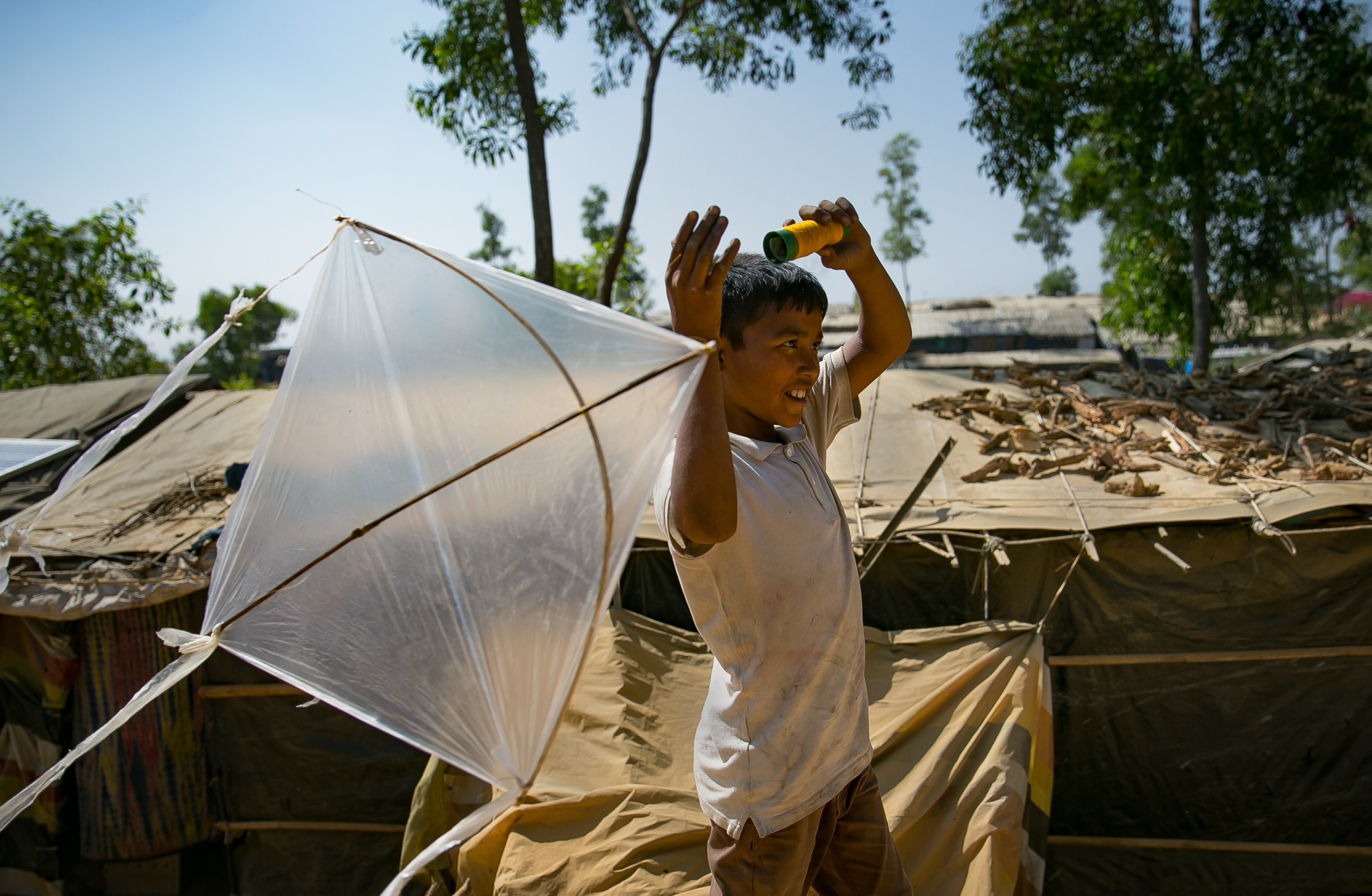 Fayes Khamal tests out a kite he's just made in the Hakimpara Rohingya refugee camp in Bangladesh. (Allison Joyce for NPR)