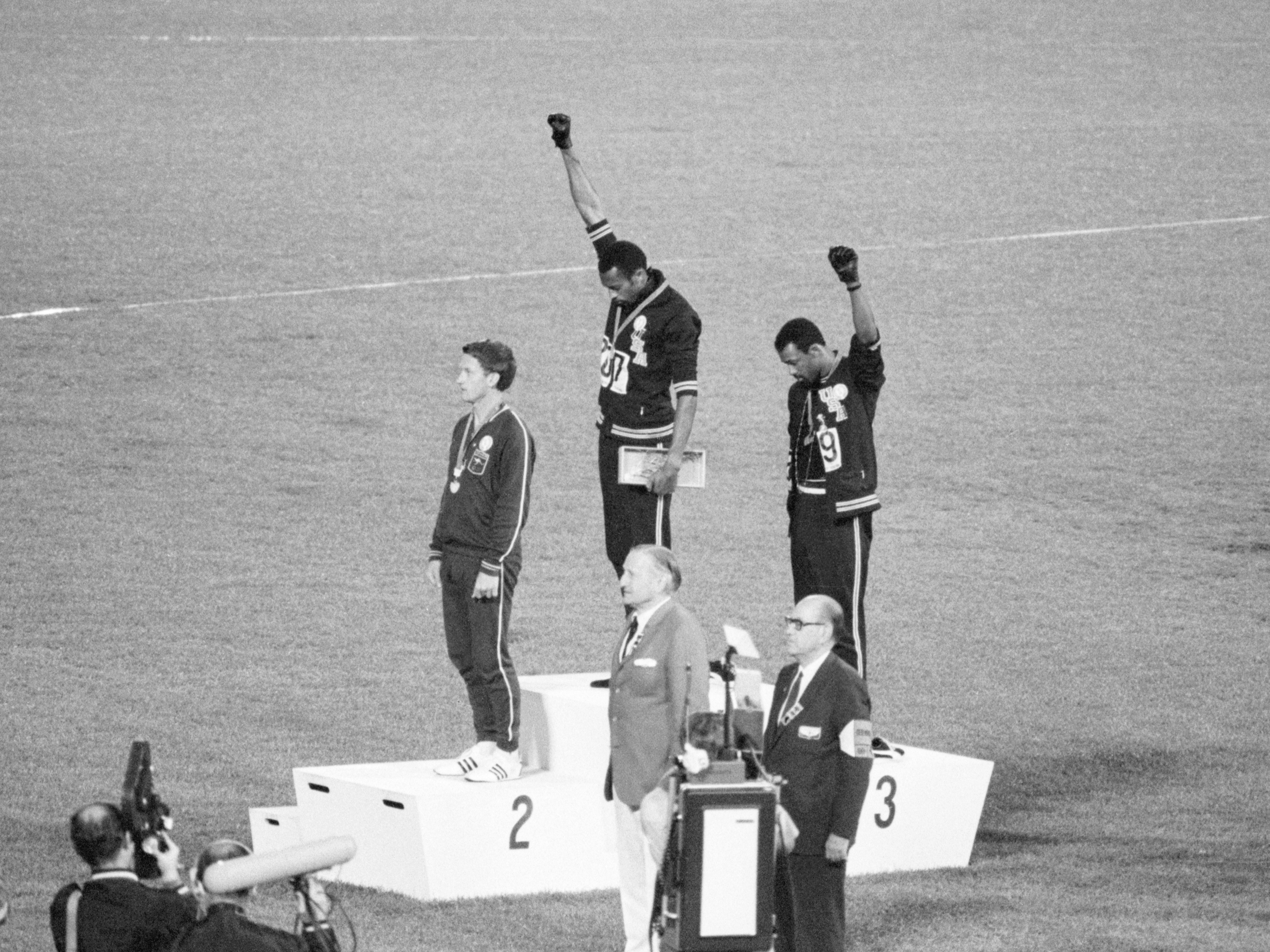 Tommie Smith and John Carlos, gold and bronze medalists in the 200-meter run at the 1968 Olympic Games, raise their fists to protest the inequity and discrimination that black people in the U.S. face. (Getty Images)