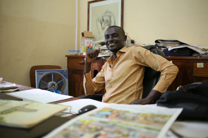 Didier Kassai uses comics to "transmit a message." His father opposed to a career in art until Kassai began earning money for his drawings. Here he sits in his office in Bangui, capital of the Central African Republic. (Cassandra Vinograd for NPR)