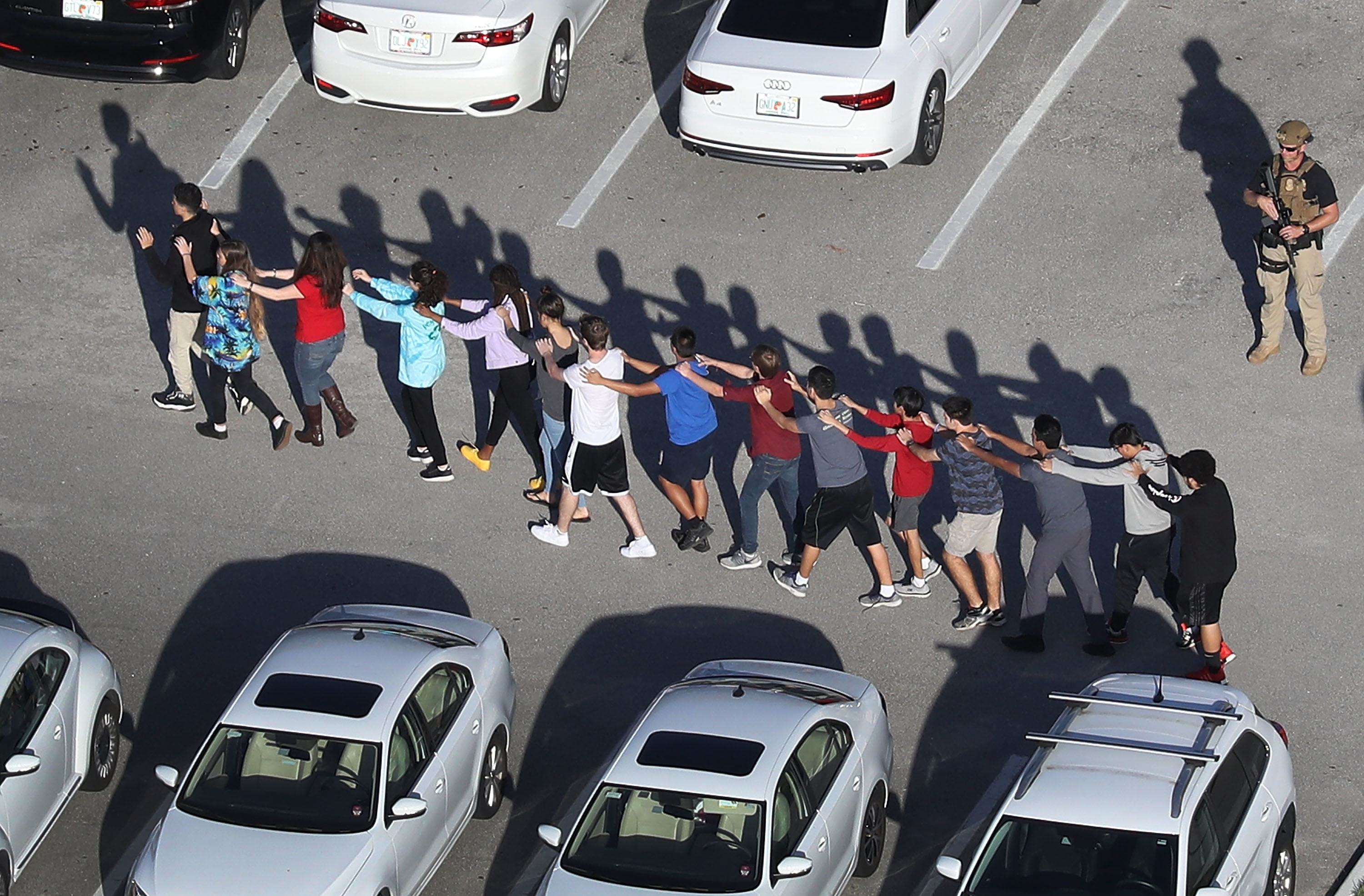 People are brought out of the Marjory Stoneman Douglas High School in Parkland, Fla., after a gunman opened fire on Wednesday. (Getty Images)