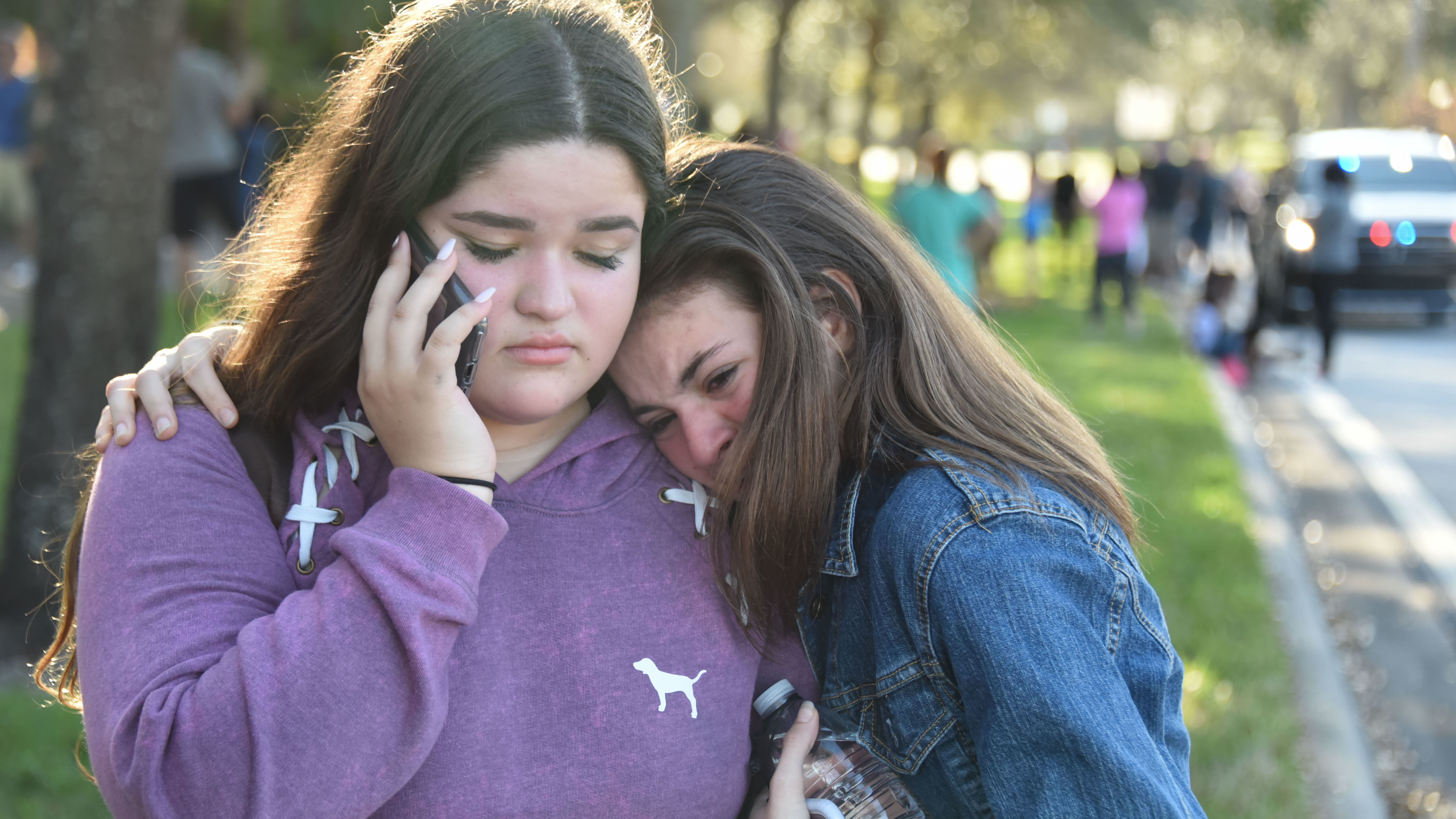 Students use their phones following the shooting at Marjory Stoneman Douglas High School in Parkland, Fla.