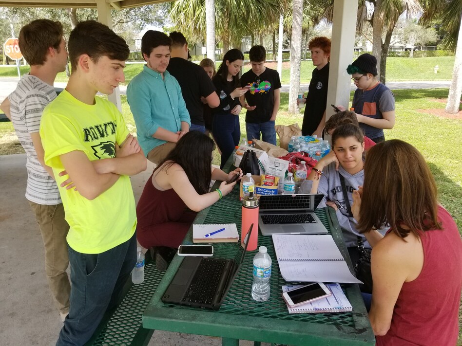 Students from Marjory Stoneman Douglas High School use a picnic table at a city park as a media center to plan their rallies on Washington, D.C., and around the country. (Brian Mann/North Country Public Radio)