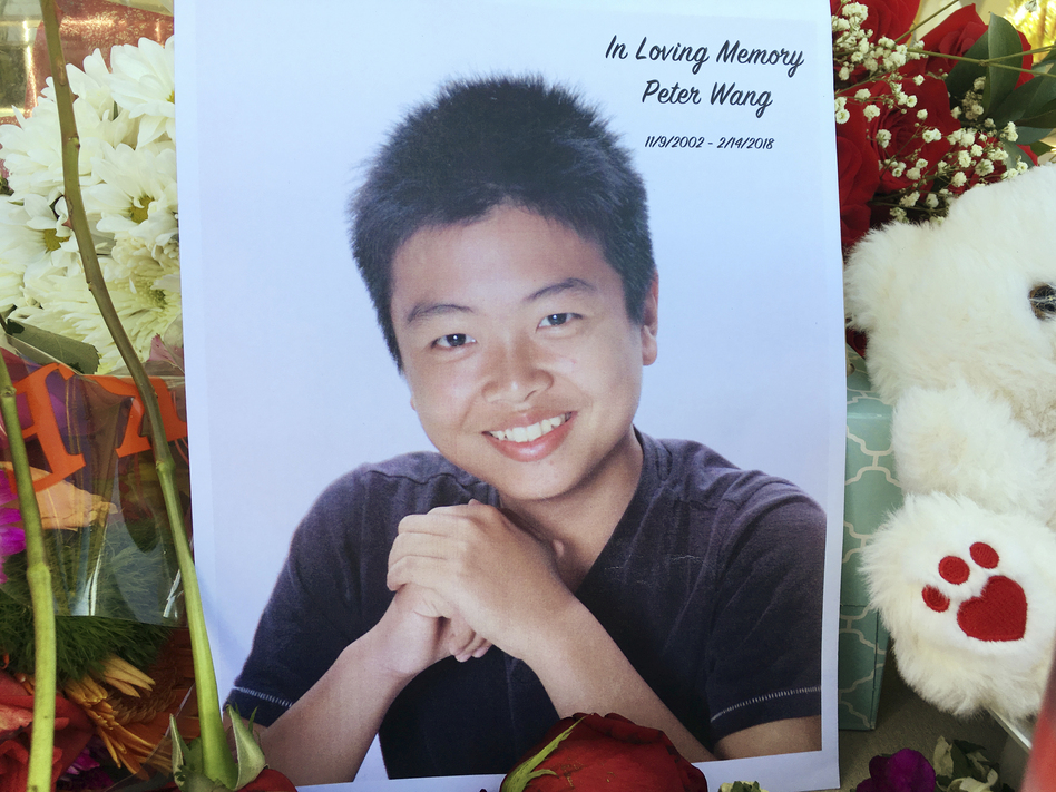Peter Wang is seen in this photo near a memorial in Parkland, Fla., on Friday. Peter, a student at Marjory Stoneman Douglas High School in Parkland, Fla., was killed when former student Nikolas Cruz opened fire at the school on Feb. 14. (Allen Breed/AP)