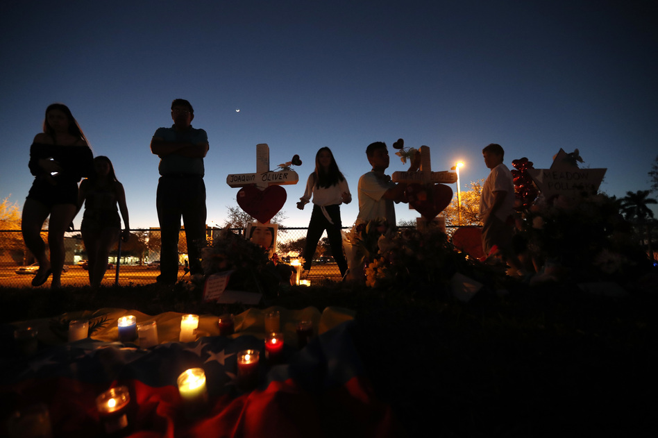 People visit a makeshift memorial outside Marjory Stoneman Douglas High School in Parkland, Fla., where 17 students and faculty were killed in a mass shooting on Feb. 14. (Gerald Herbert/AP)