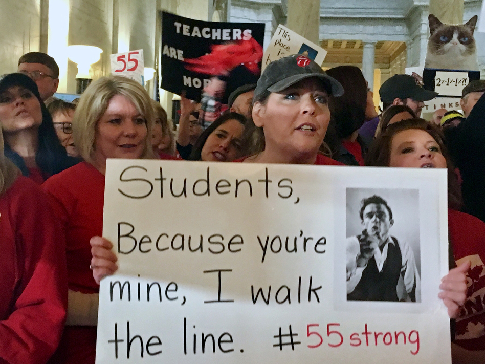 Jennifer Hanner, a first-year teacher from Harts, W.Va., holds a sign Thursday at the Capitol in Charleston. Teachers statewide went on strike Thursday over pay and benefits. (John Raby/AP)