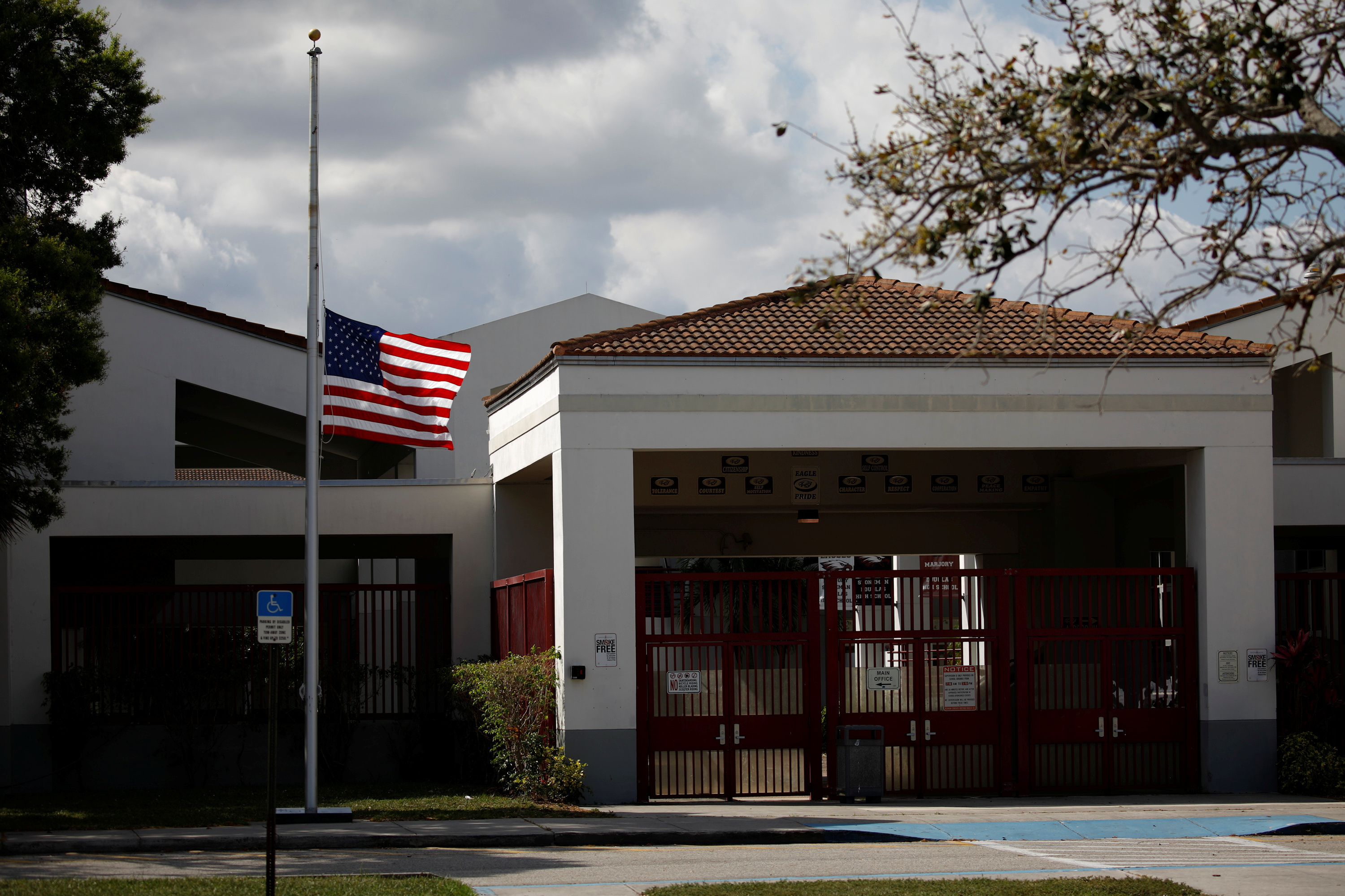 A flag flies at half mast at the entrance to Marjory Stoneman Douglas High School, following a mass shooting at the in Parkland, Fla., school earlier this month. (Reuters)