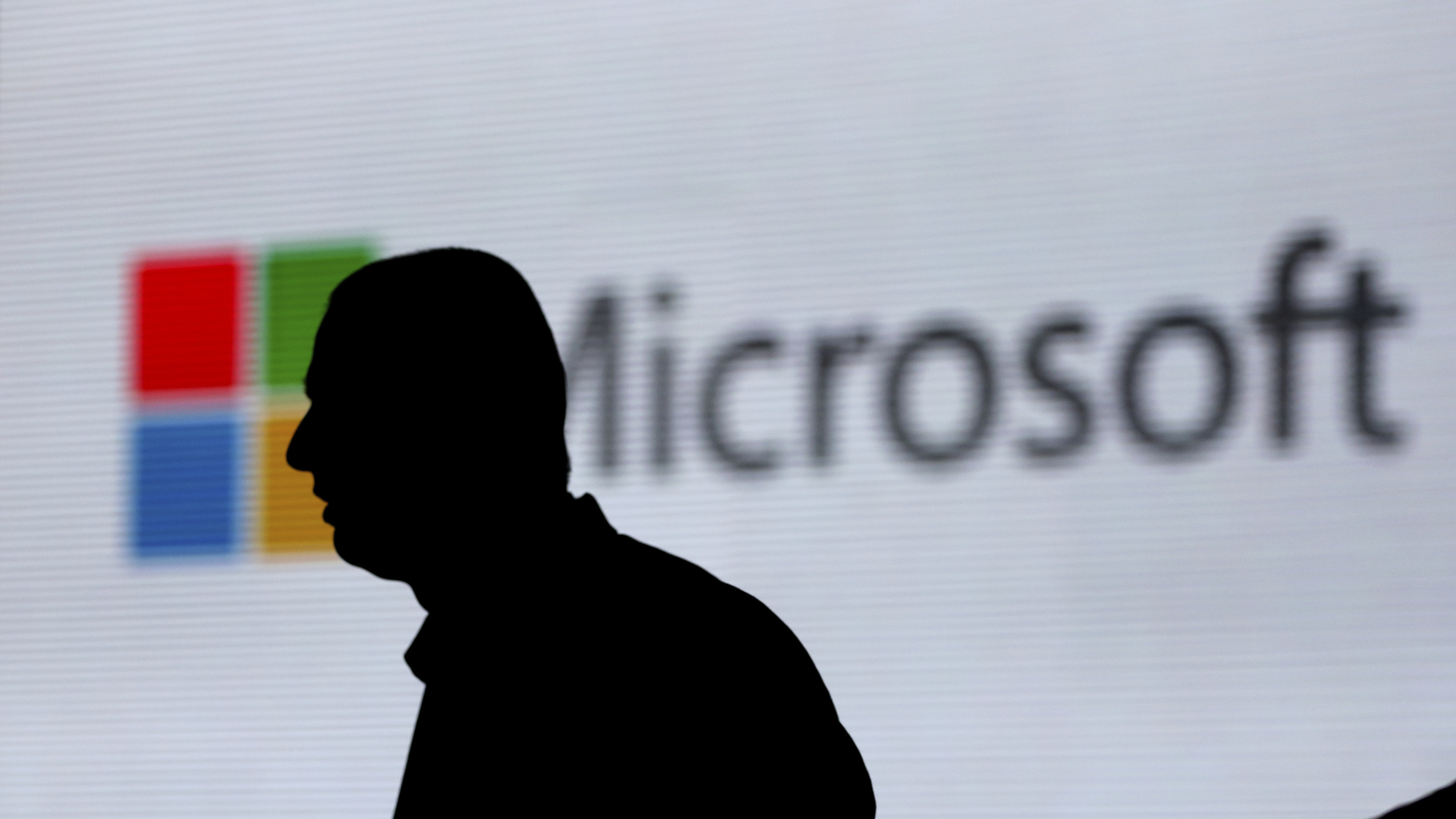 An unidentified man walks in front of the Microsoft logo at an event in New Delhi. Microsoft is at the center of a Supreme Court case on whether it has to turn over emails stored overseas.