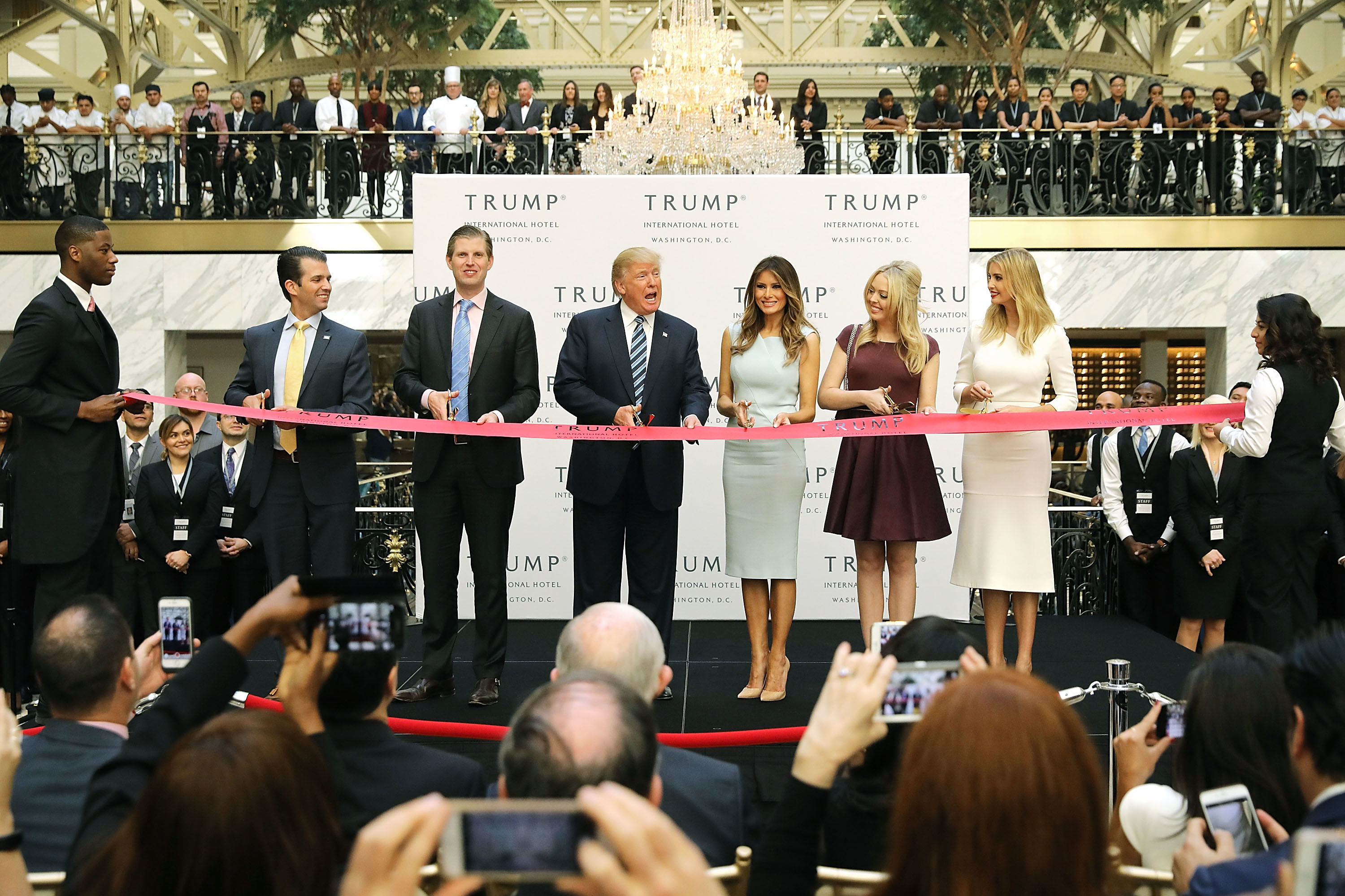 Donald Trump, center, then the Republican presidential nominee, attends the opening of the Trump International Hotel in Washington, D.C., in October 2016. After winning the election, Trump did not divest himself of his business holdings or put them in a blind trust. Lawsuits have been filed that allege he is violating anti-corruption provisions in the Constitution. (Getty Images)