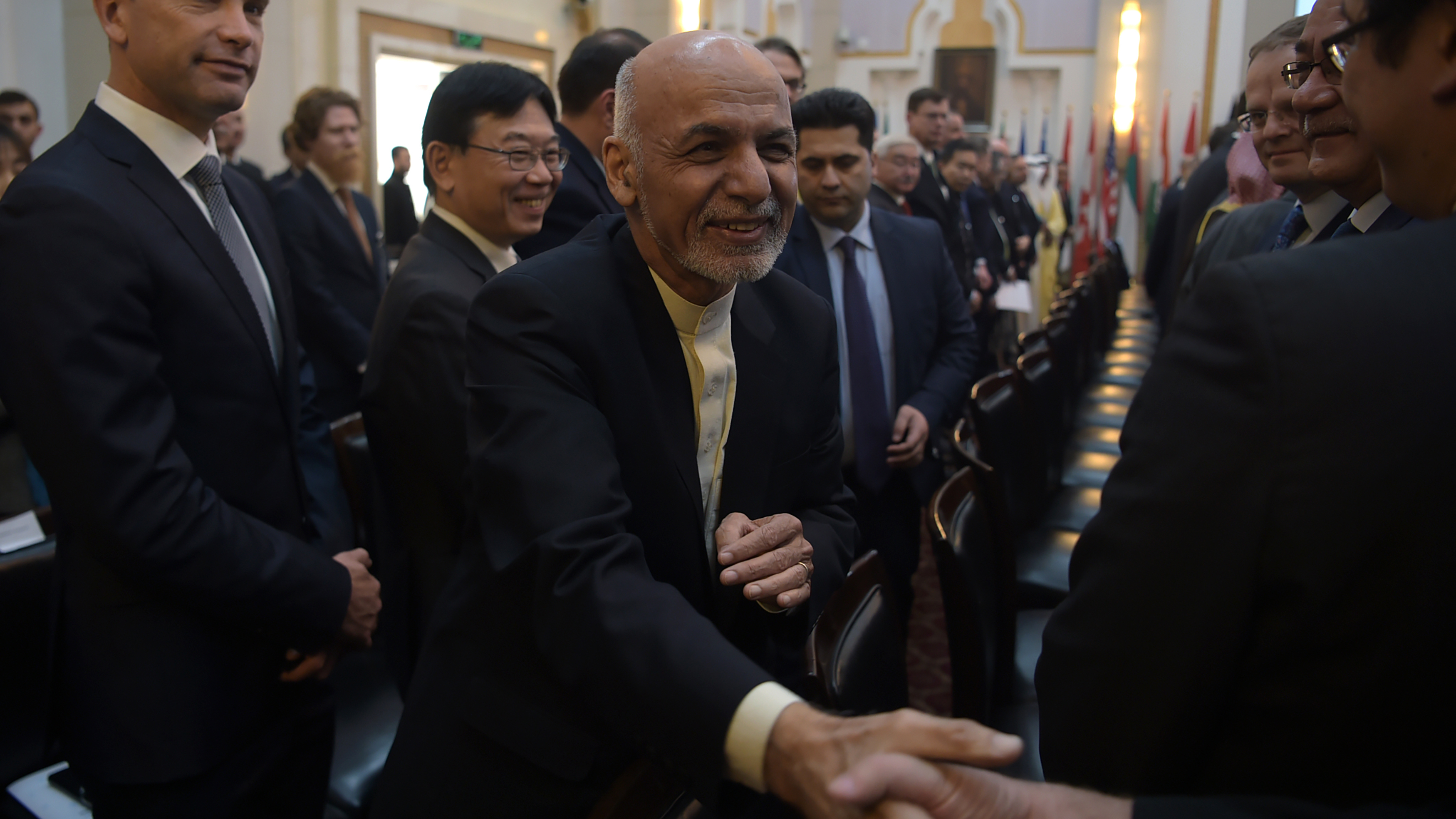Afghan President Ashraf Ghani shakes hands with a foreign delegate at the Kabul Process conference in the country's capital Wednesday. During the conference, Ghani called on the Taliban to participate in peace talks with the Afghan government. (AFP/Getty Images)
