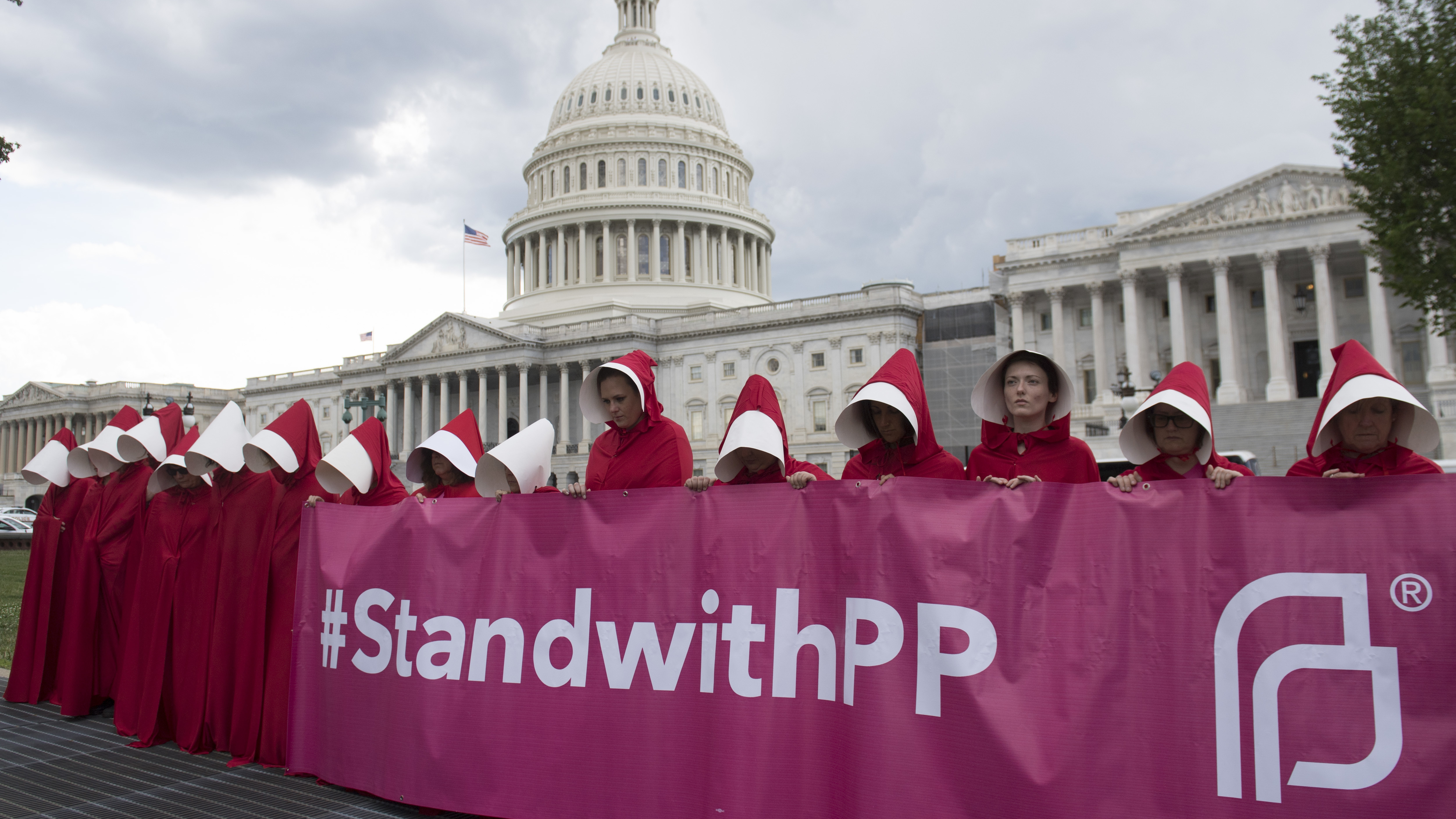 Supporters of Planned Parenthood dressed as characters from <em>The Handmaid's Tale</em> protest last June outside the Capitol against Senate Republicans' health care bill. (AFP/Getty Images)