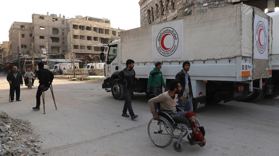 A convoy of Syrian Red Crescent trucks arrives in Douma, in the Syrian rebel-held enclave of Eastern Ghouta, on Monday. This aid convoy is the first to reach the besieged area in weeks. (Amer Almohibany/AFP/Getty Images)