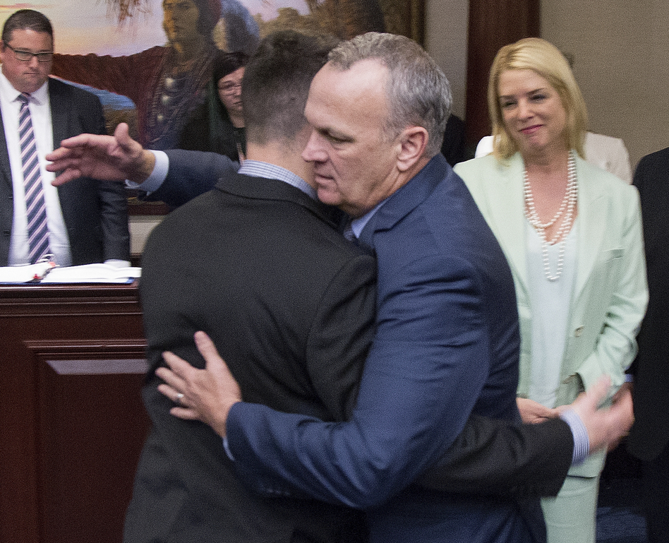 Florida Speaker of the House Richard Corcoran (center) hugs Hunter Pollack, whose sister was one of the 17 people killed last month in a mass shooting at a South Florida high school. The state House on Wednesday passed a package of measures intended to prevent another school shooting, sending the bill to the governor for his approval. (Mark Wallheiser/AP)
