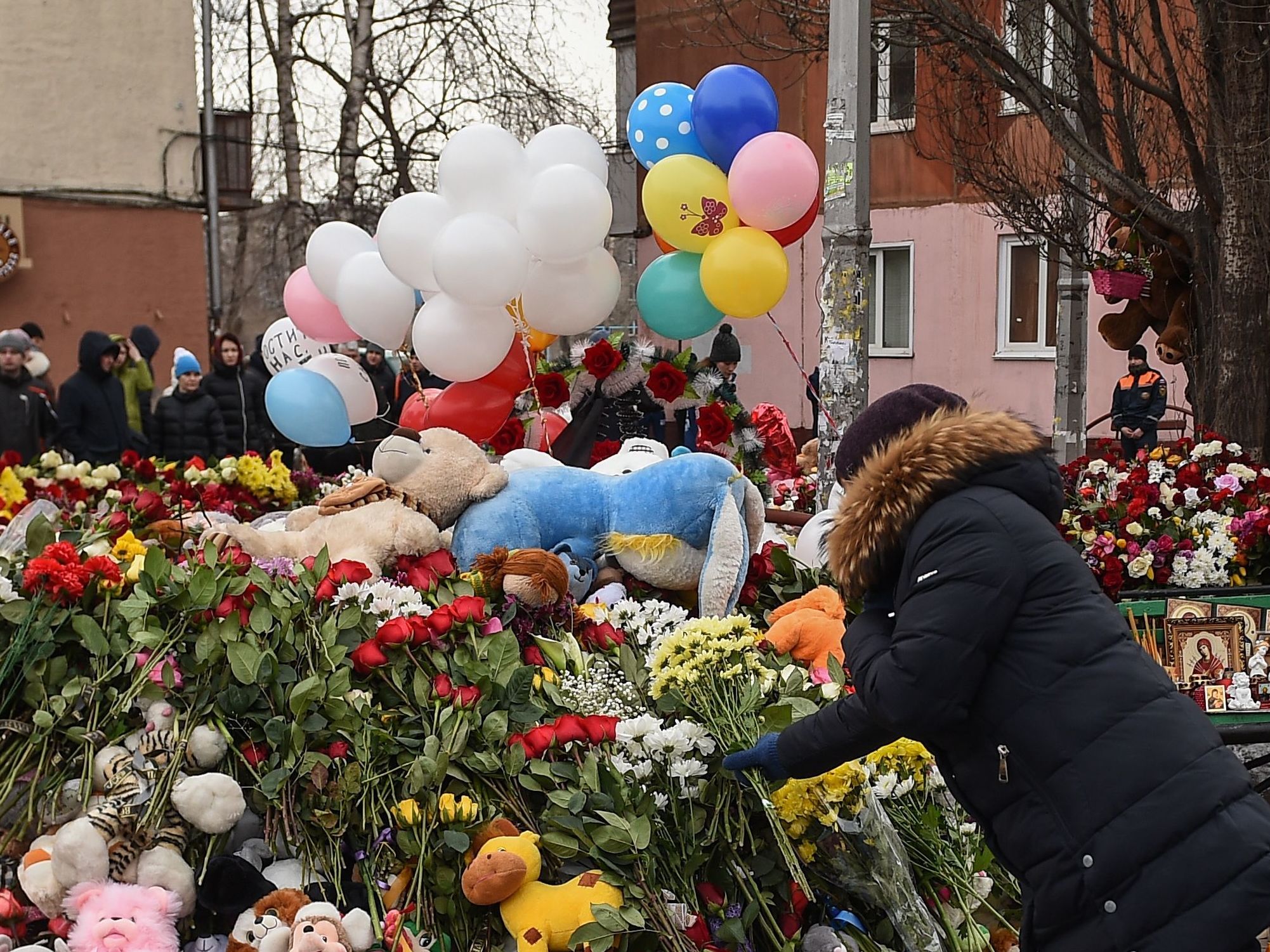 People lay flowers at a makeshift memorial in tribute to the victims of a fire at a shopping centre in Kemerovo, Russia on Tuesday. Russian authorities denounced what they called &quot;flagrant violations&quot; of safety norms that led to the deaths of 64 people, many of them children, in a fire at a busy shopping mall in an industrial city in Siberia. (AFP/Getty Images)