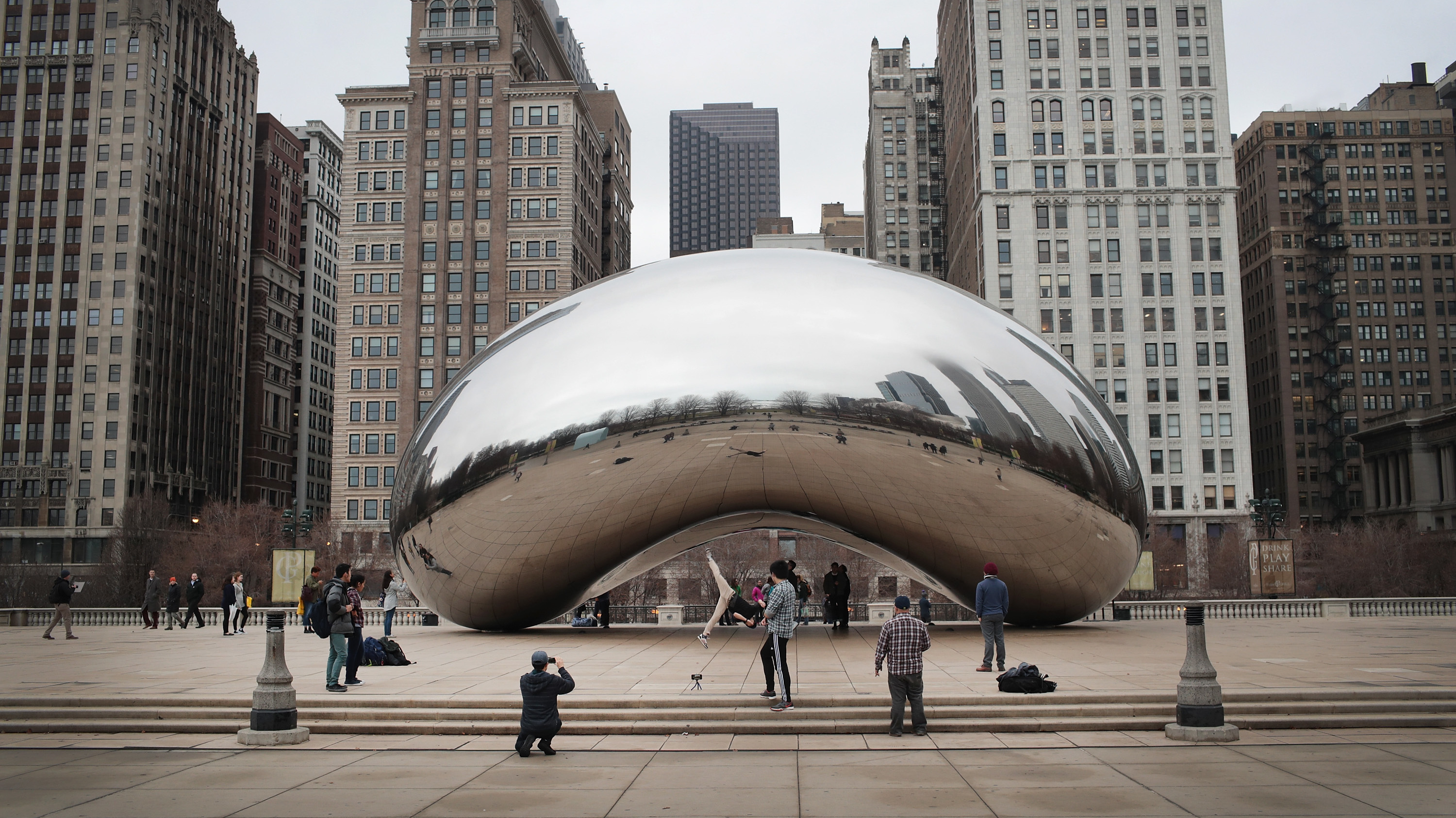 Visitors look over the Cloud Gate sculpture, also known as the "bean," in Millennium Park in Chicago, Illinois.